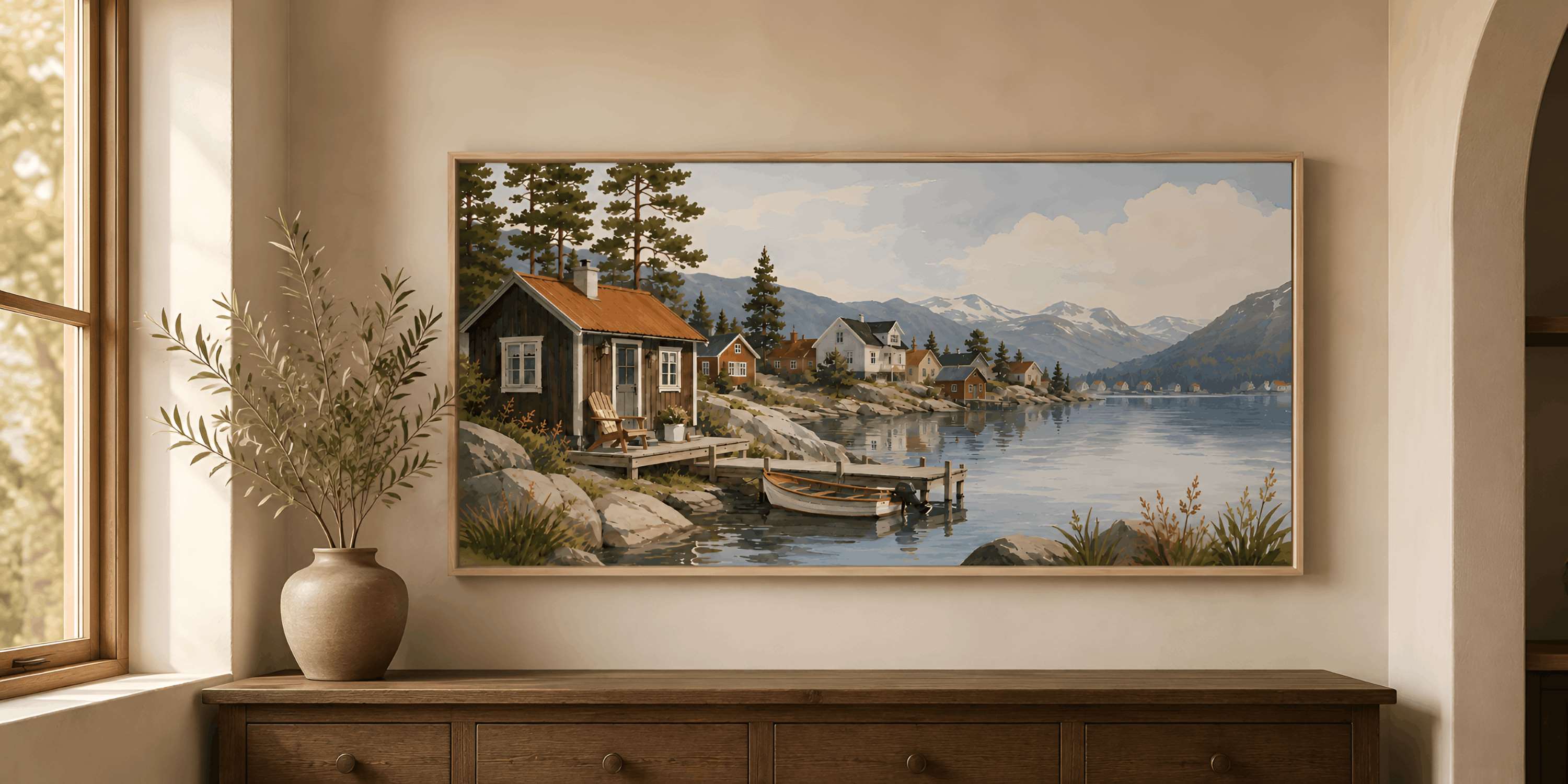 Framed Nordic coastal landscape wall art displayed above an aged wood console in a warmly lit neutral interior.