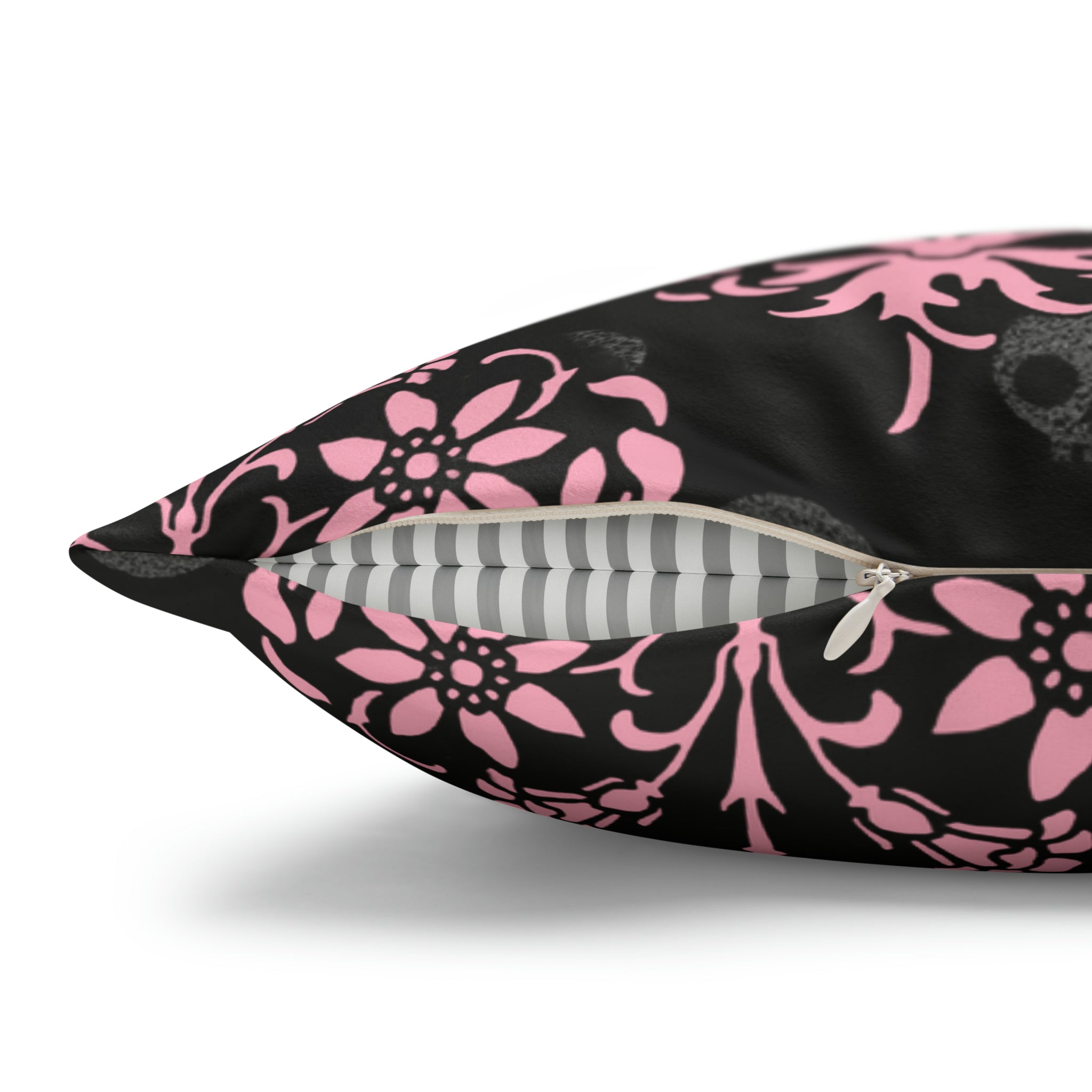 Decorative pillow with a black base and pink floral pattern zipper showing.