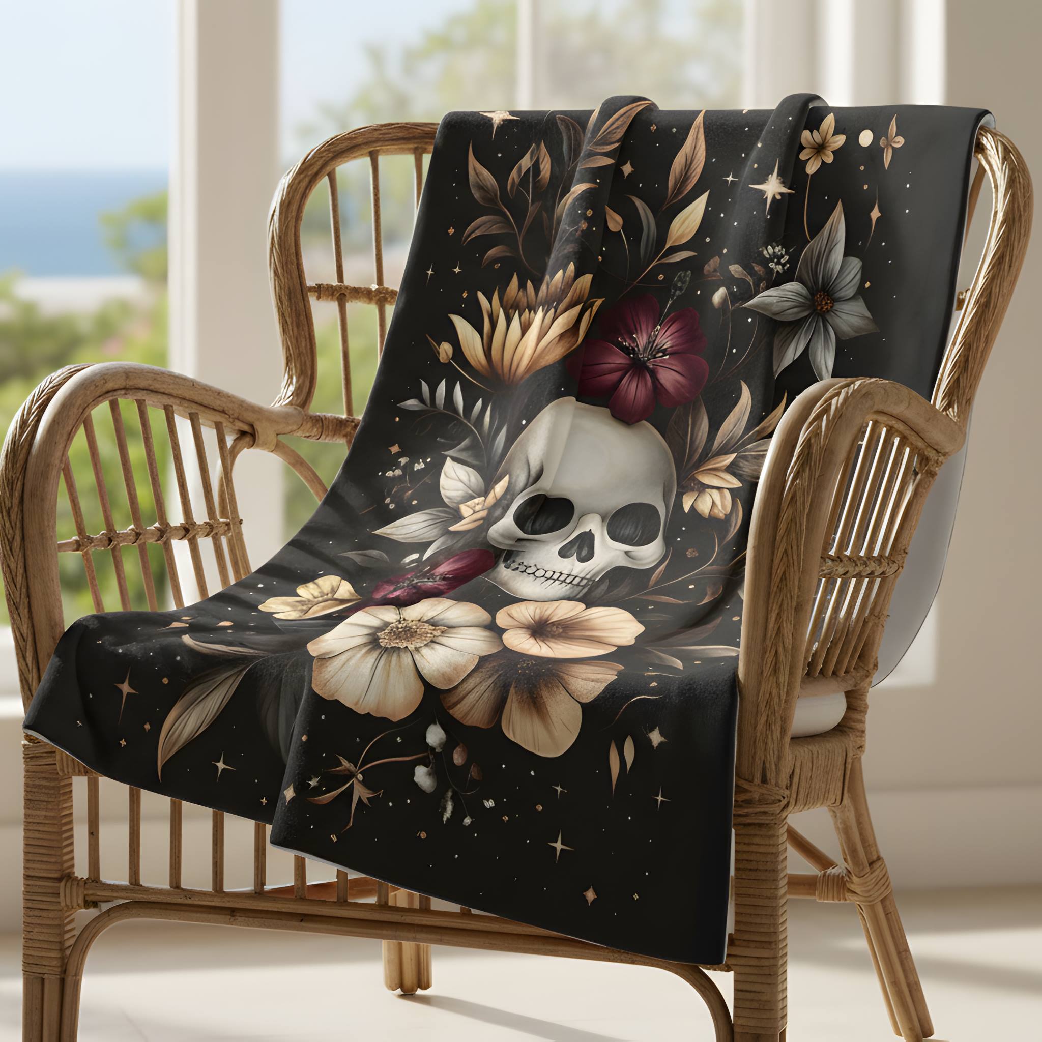 Gothic floral velveteen throw blanket draped on wicker chair with skull, taupe petals, and plum accents.