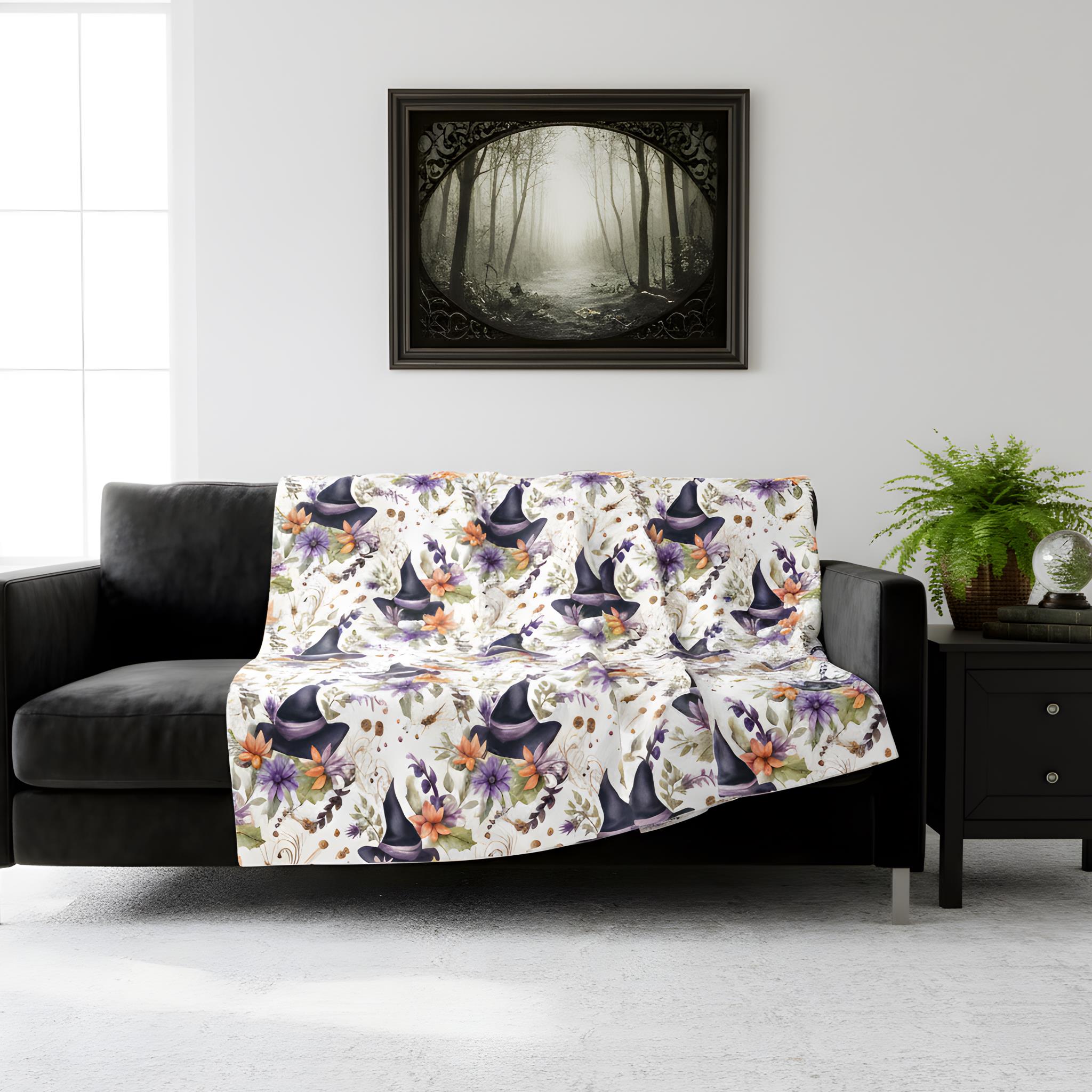Floral Witch Hat blanket styled on a black sofa in a moody whimsigoth living room.