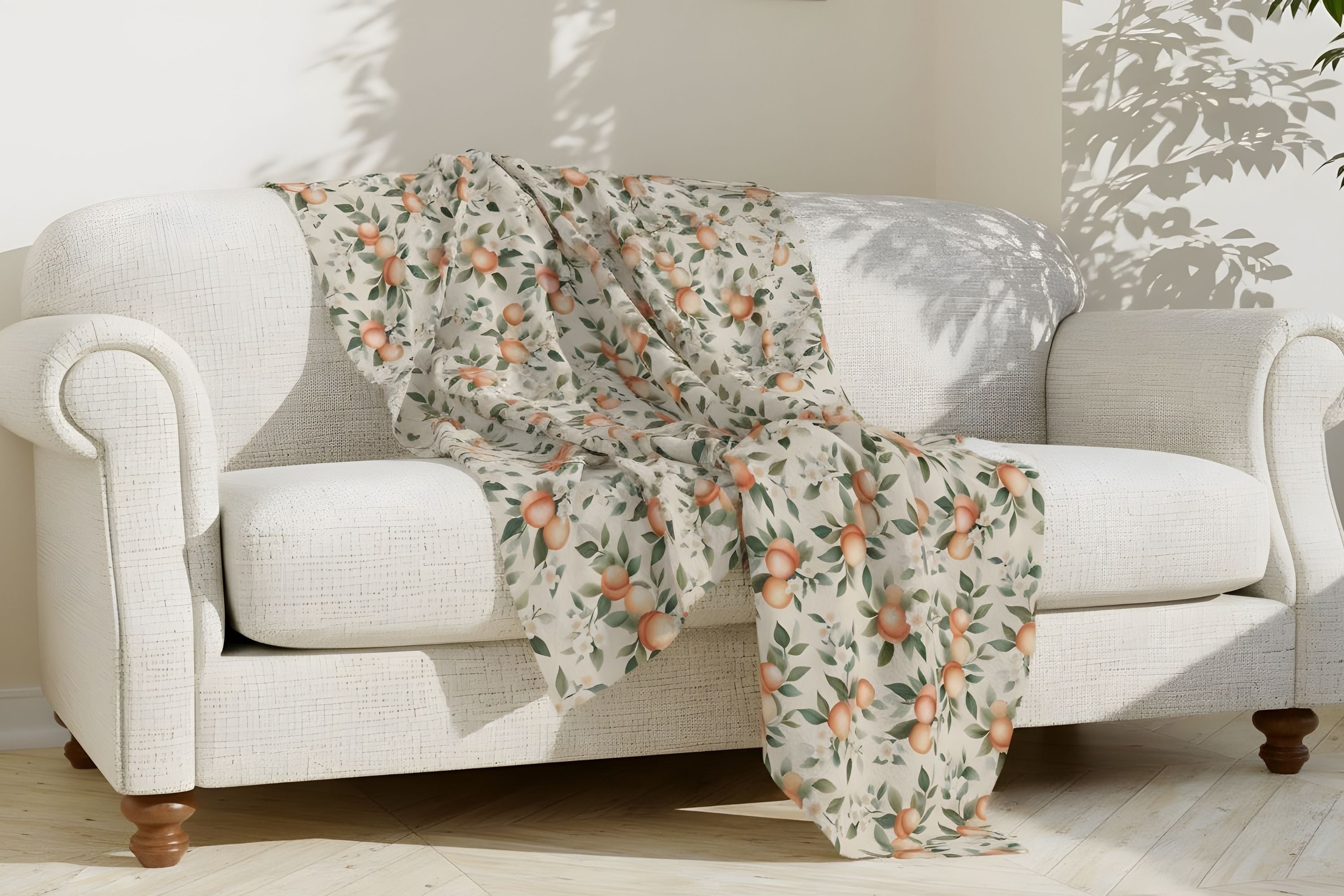 A Mediterranean Farmhouse-style, peach patterned throw blanket draped over a white sofa.