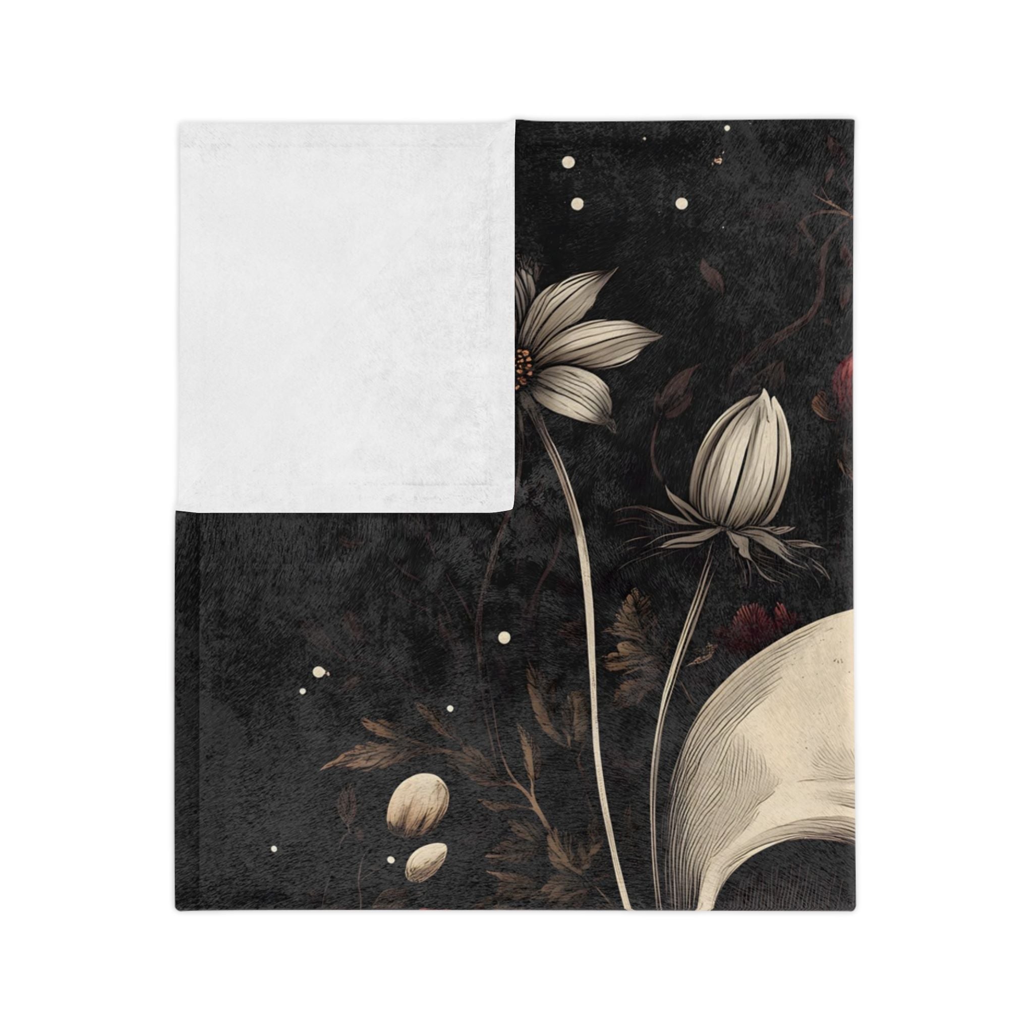 Folded Dark floral and skull velveteen throw blanket showing white underside.