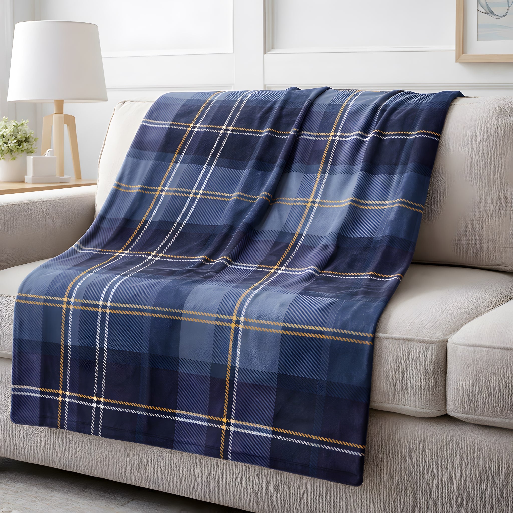 Blue plaid blanket draped over a beige sofa in a living room setting.
