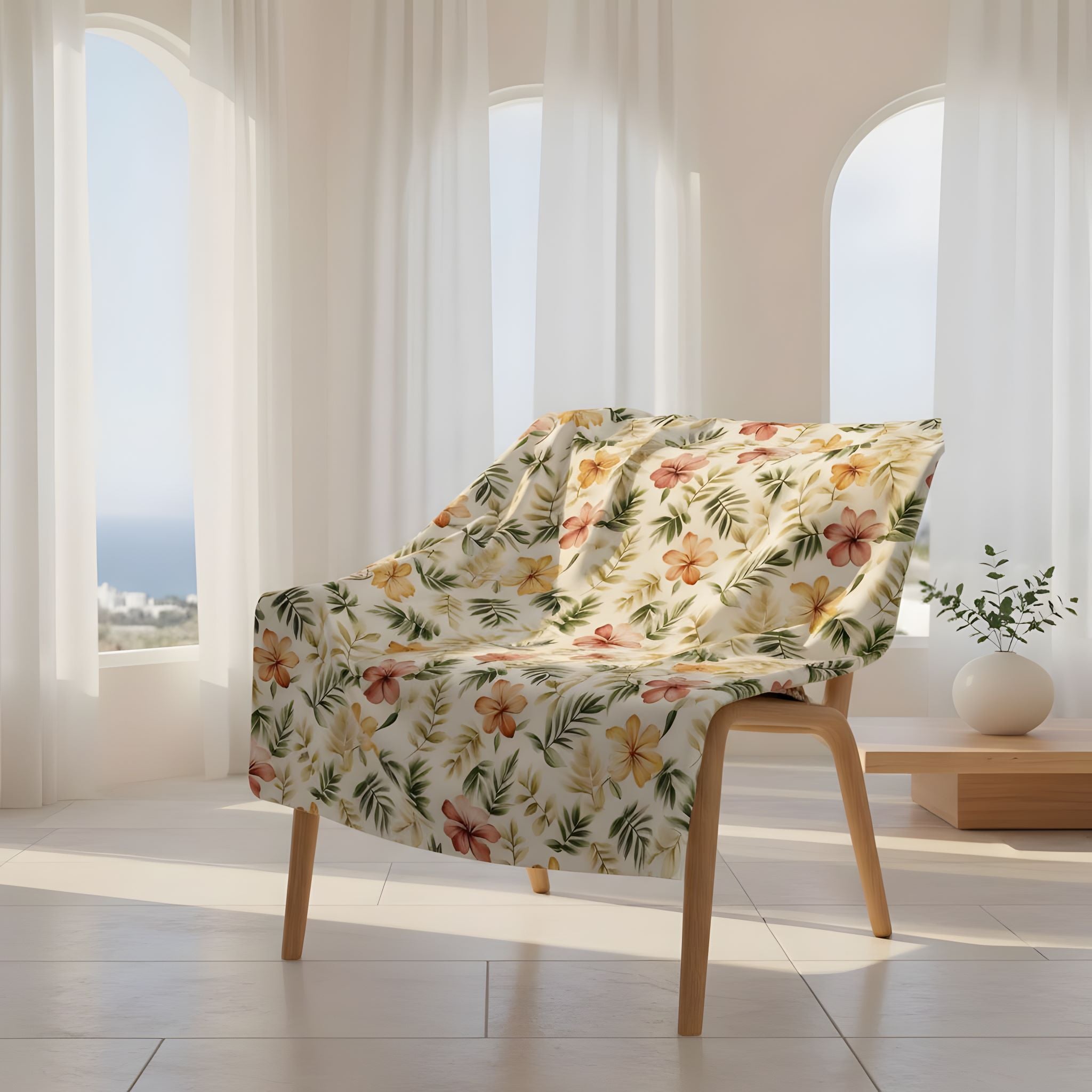 Coastal Mediterranean floral throw blanket draped over woven chair in velveteen or sherpa.