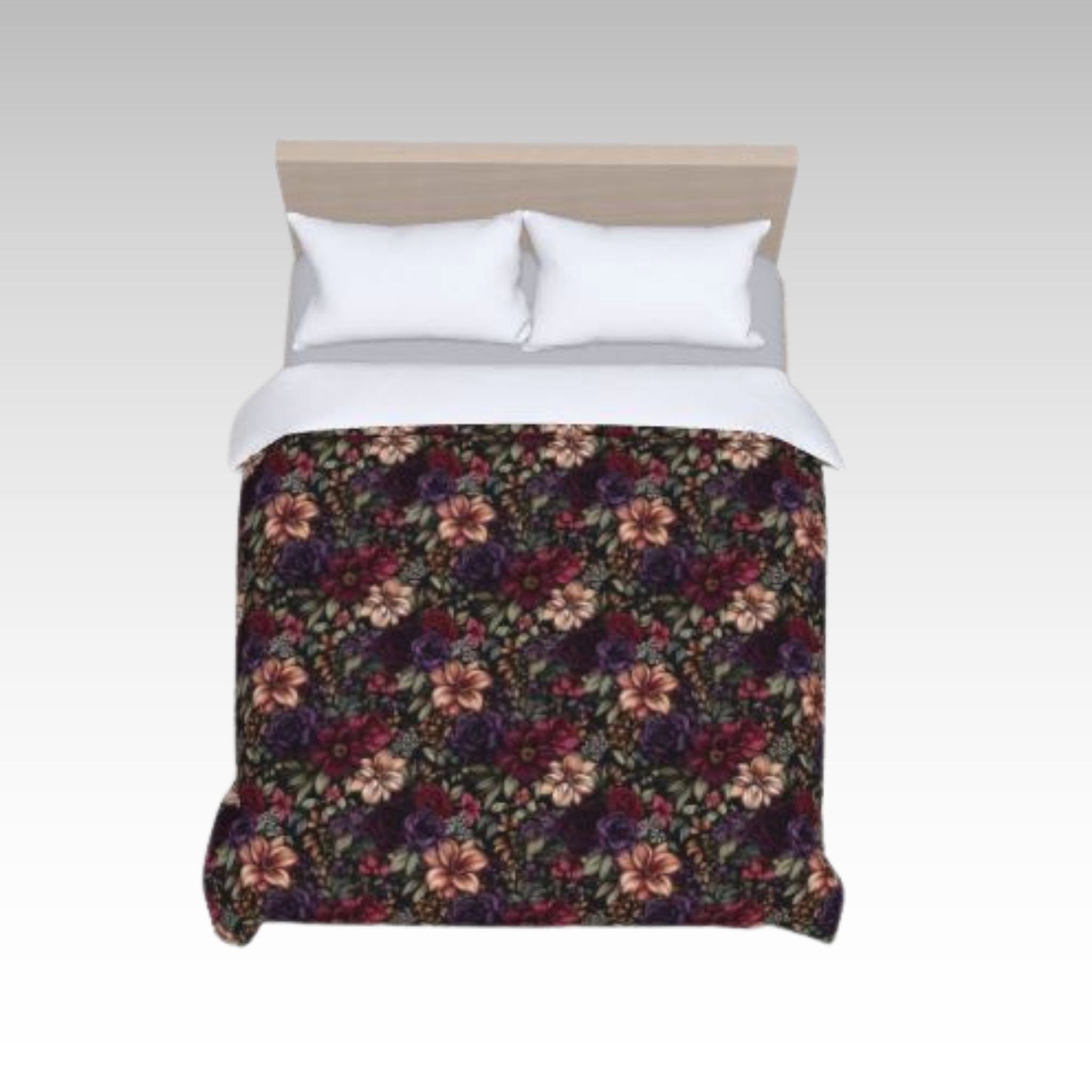 Top view of dark floral duvet cover on a bed with white pillows.