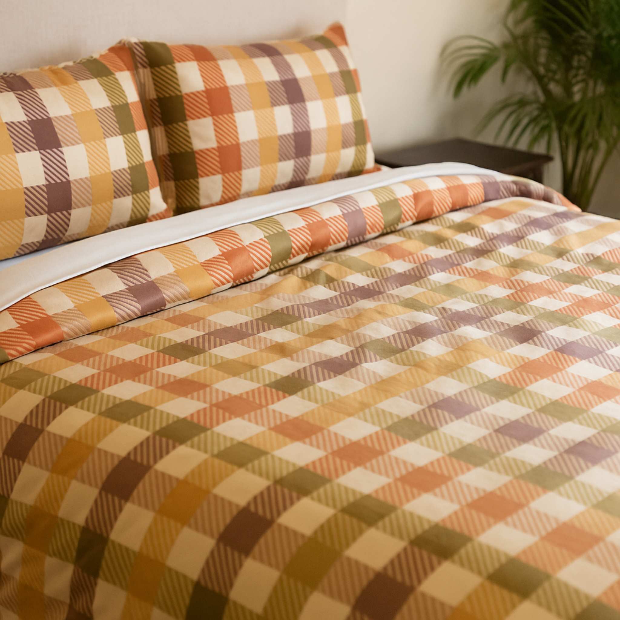 Plaid bedspread with autumn colors on a bed in a room setting.