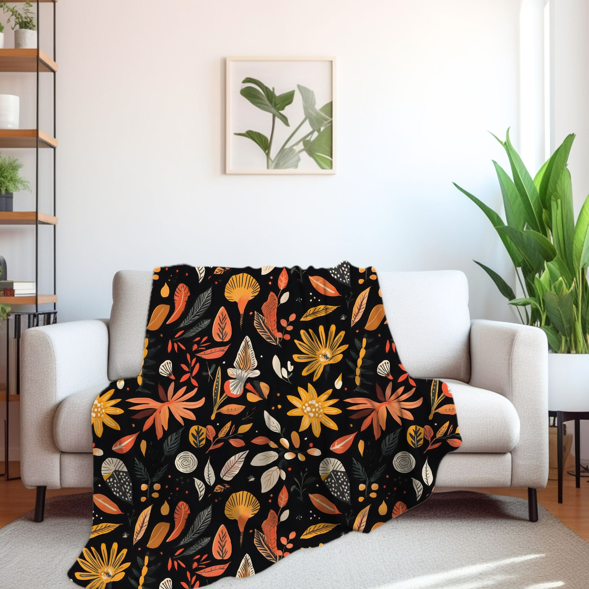 A throw blanket with a floral and leaf pattern in autumn colors draped over a modern sofa, complementing the room's decor.