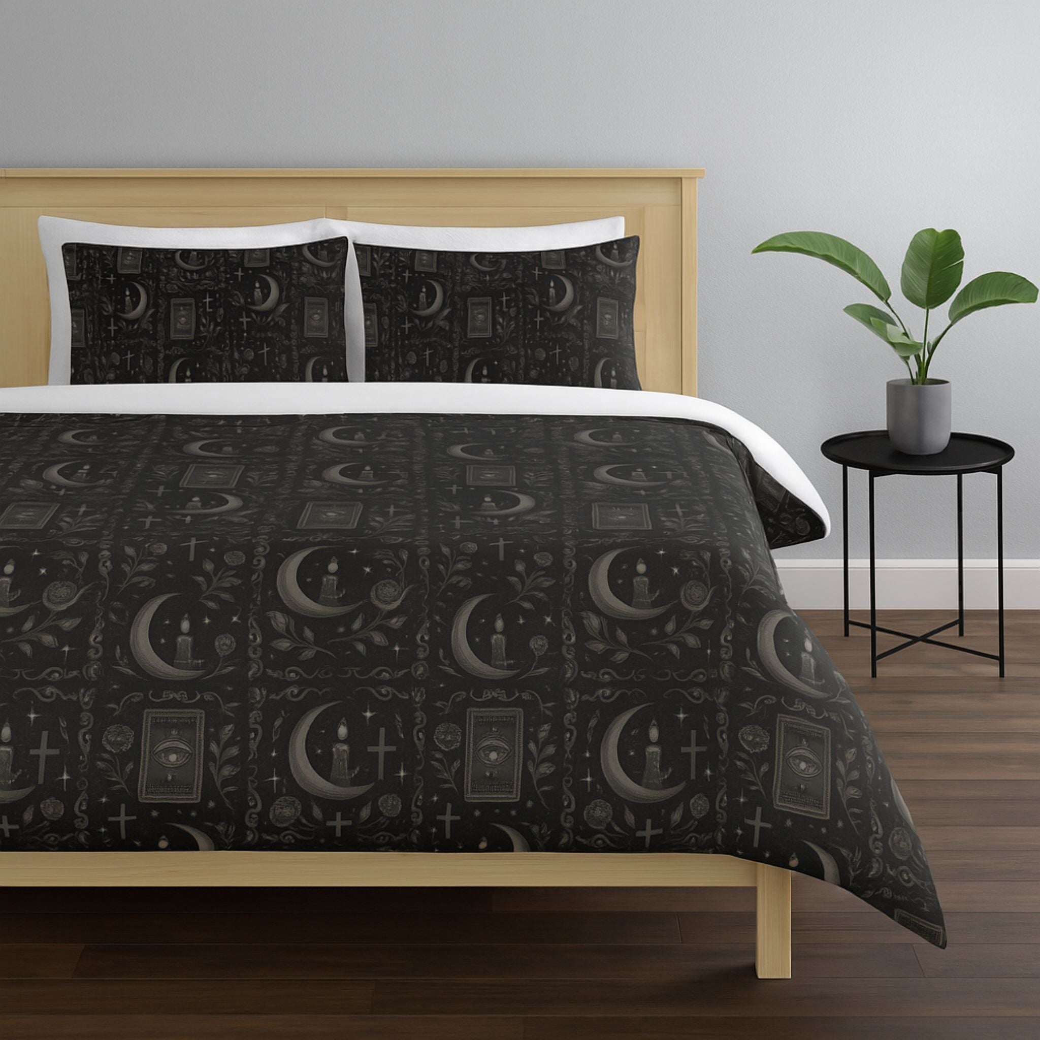 Bed with black moon and tarot patterned bedding and white pillows in a room setting.