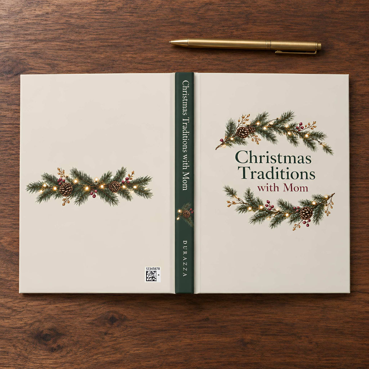 A hardcover book titled "Christmas Traditions with Mom" lies open on a dark wood tabletop, with a gold pen placed above it. The cover and spine are warm cream with green pine garland illustrations, small warm lights, and dark green text.