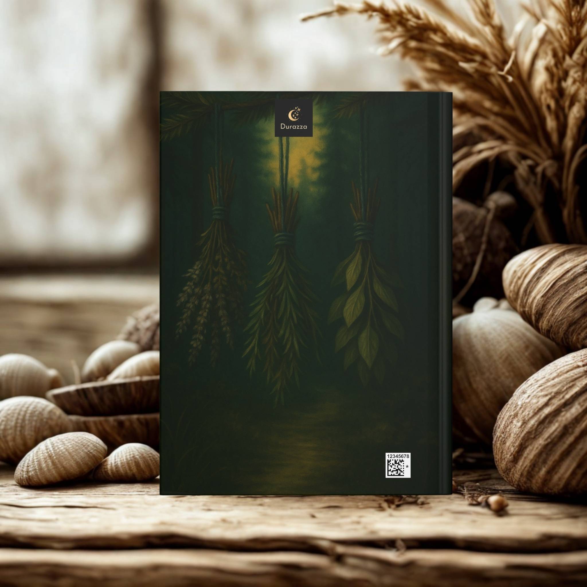 Back cover of the journal with herbs hanging. It is sitting on a wooden surface with natural elements