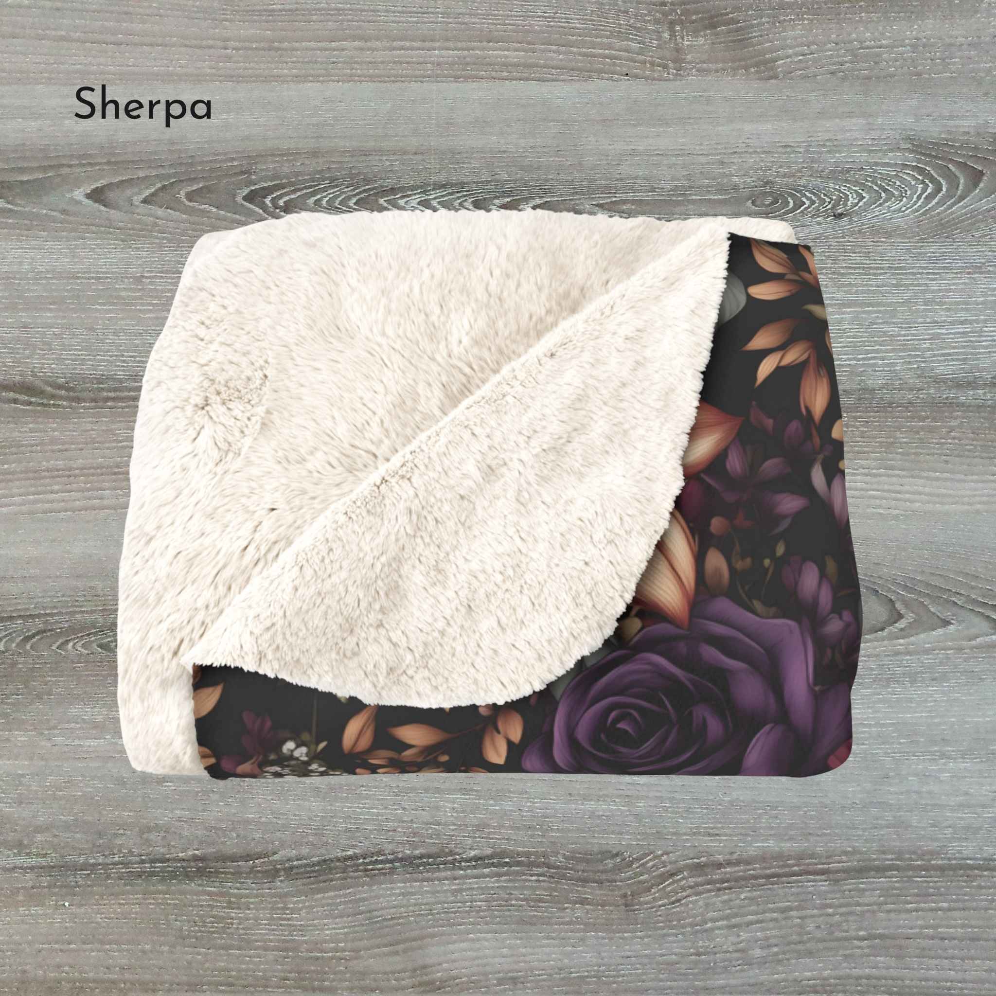 Floral patterned blanket with white sherpa surface on a wooden background