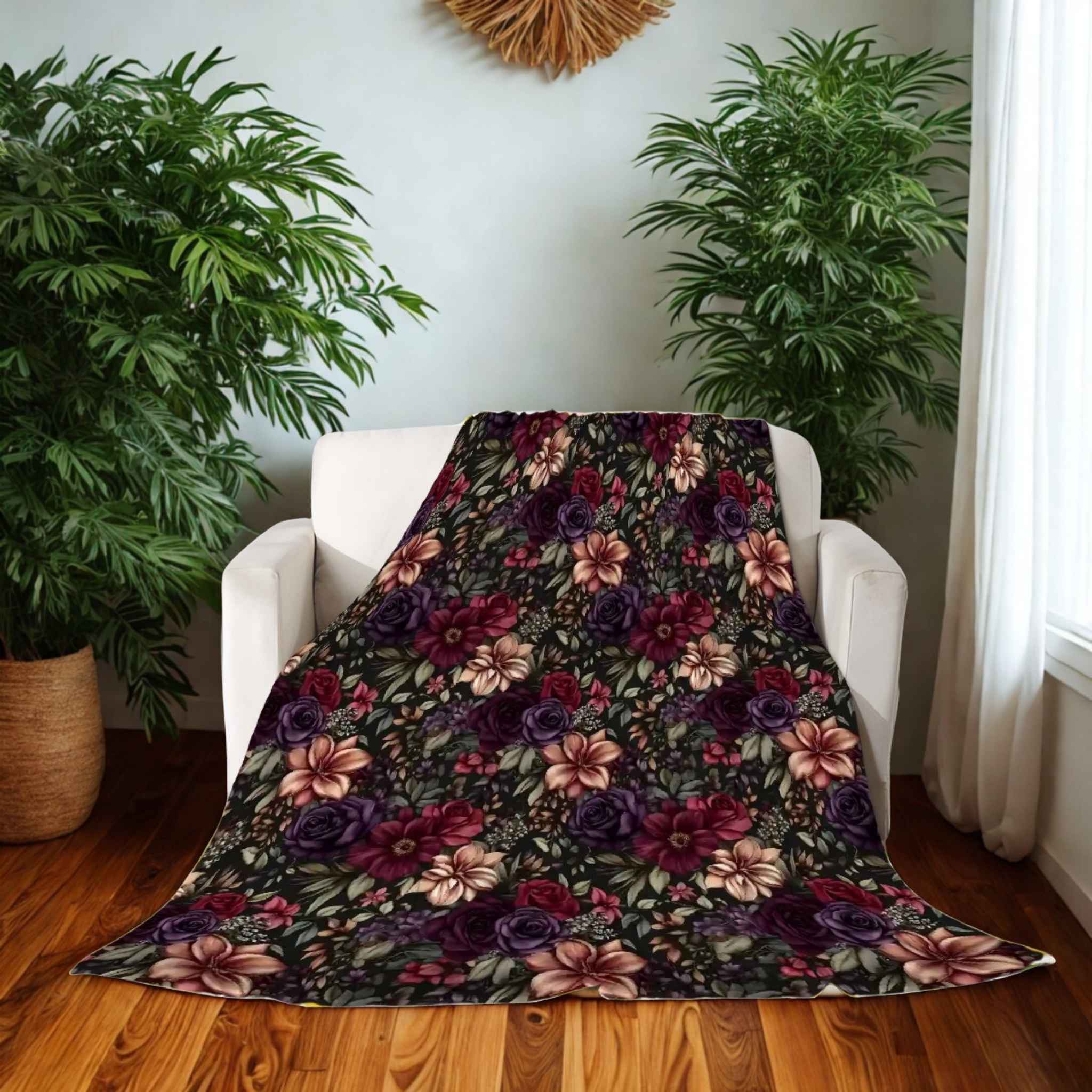 Floral patterned blanket draped over a white chair in a room with plants and a window.