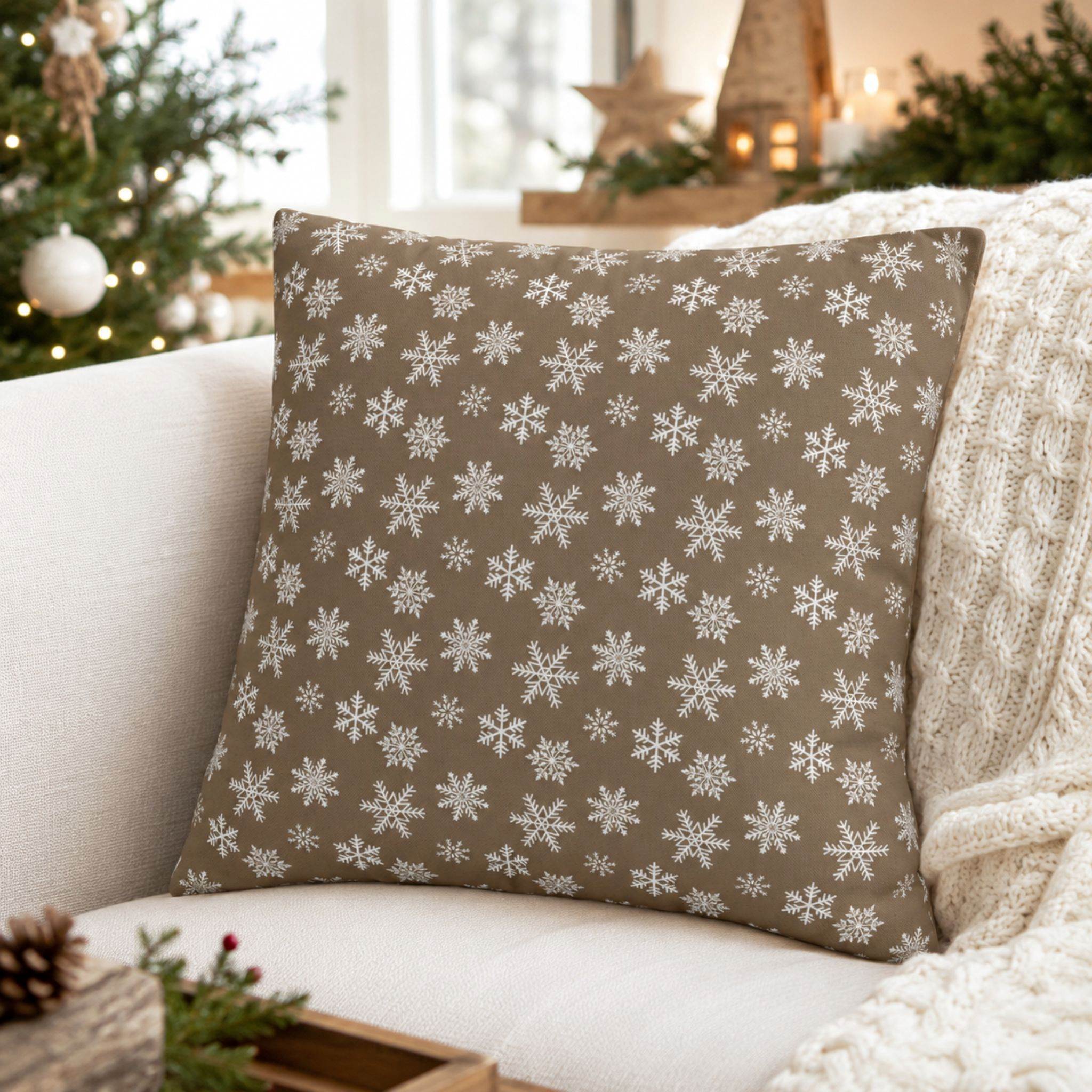 Taupe snowflake pillow cover styled on sofa with Christmas tree decor.