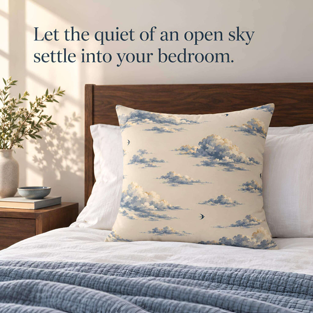 Cloudveil cloud pillow cover styled on a bed with white pillows, a blue blanket, and a wood headboard.