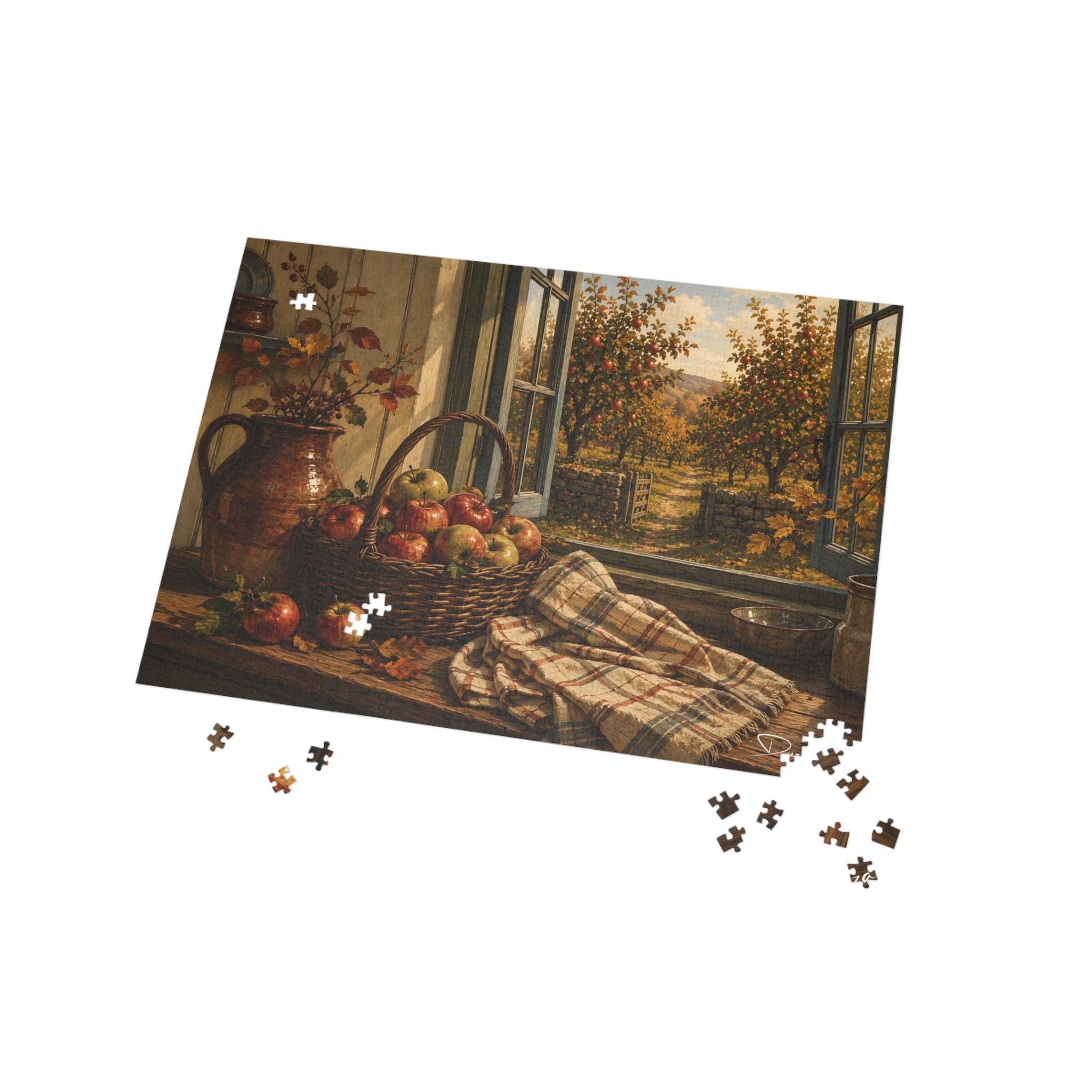 A 500 piece jigsaw puzzle showing a still life scene with apples in a basket, a terracotta jug, and a plaid blanket by an open window, photographed on a white background with several loose puzzle pieces scattered below.
