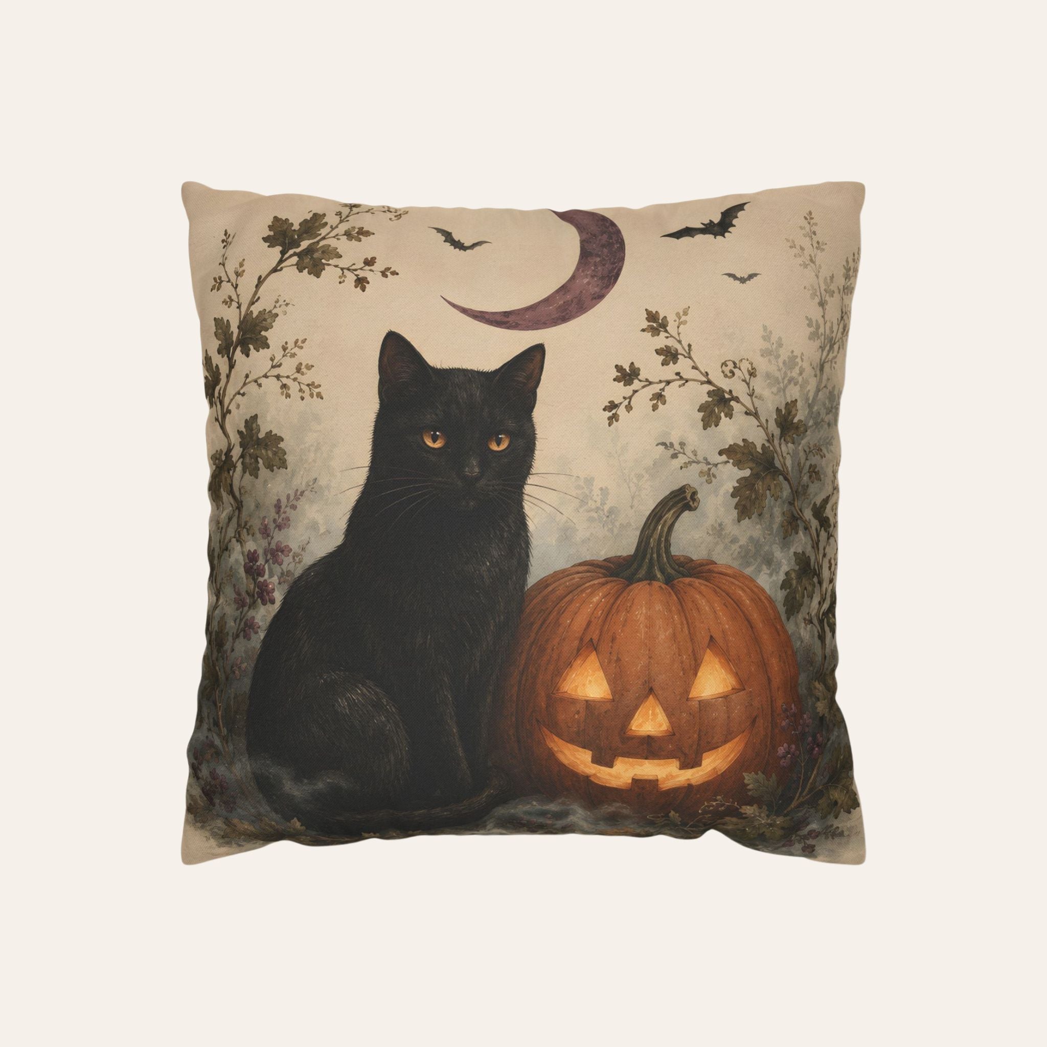 A square decorative throw pillow featuring a Halloween-themed illustration of a black cat next to a carved orange pumpkin, with a crescent moon, bats, and misty foliage on a beige background.