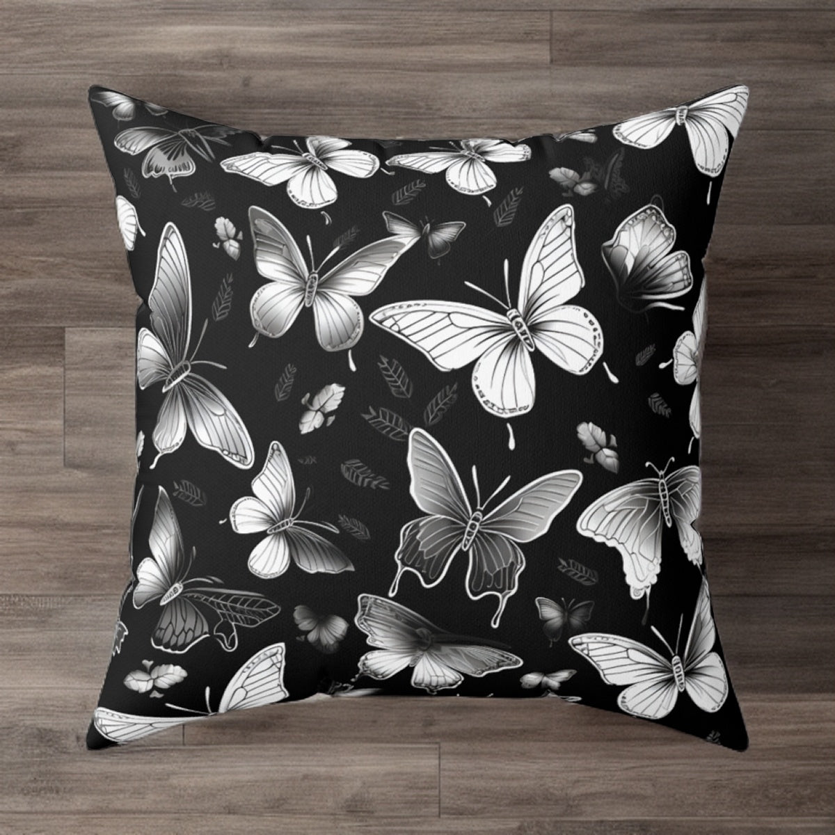 A square pillow cover with a black and white butterfly pattern on a faux suede texture.