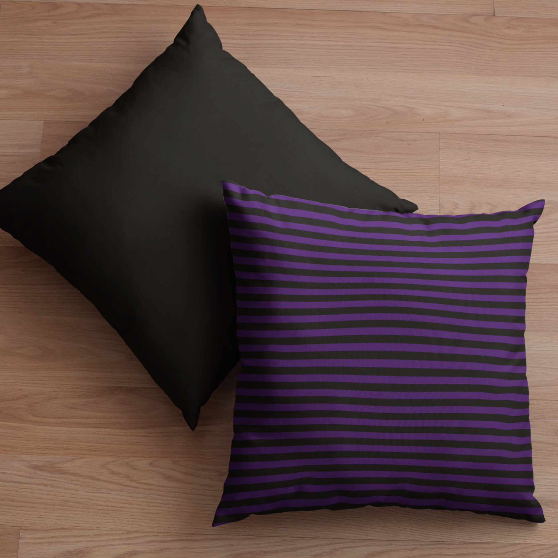 One faux suede pillow with bold purple and black stripes on a wooden floor. One side is black, and the other has a mix of purple and black stripes.