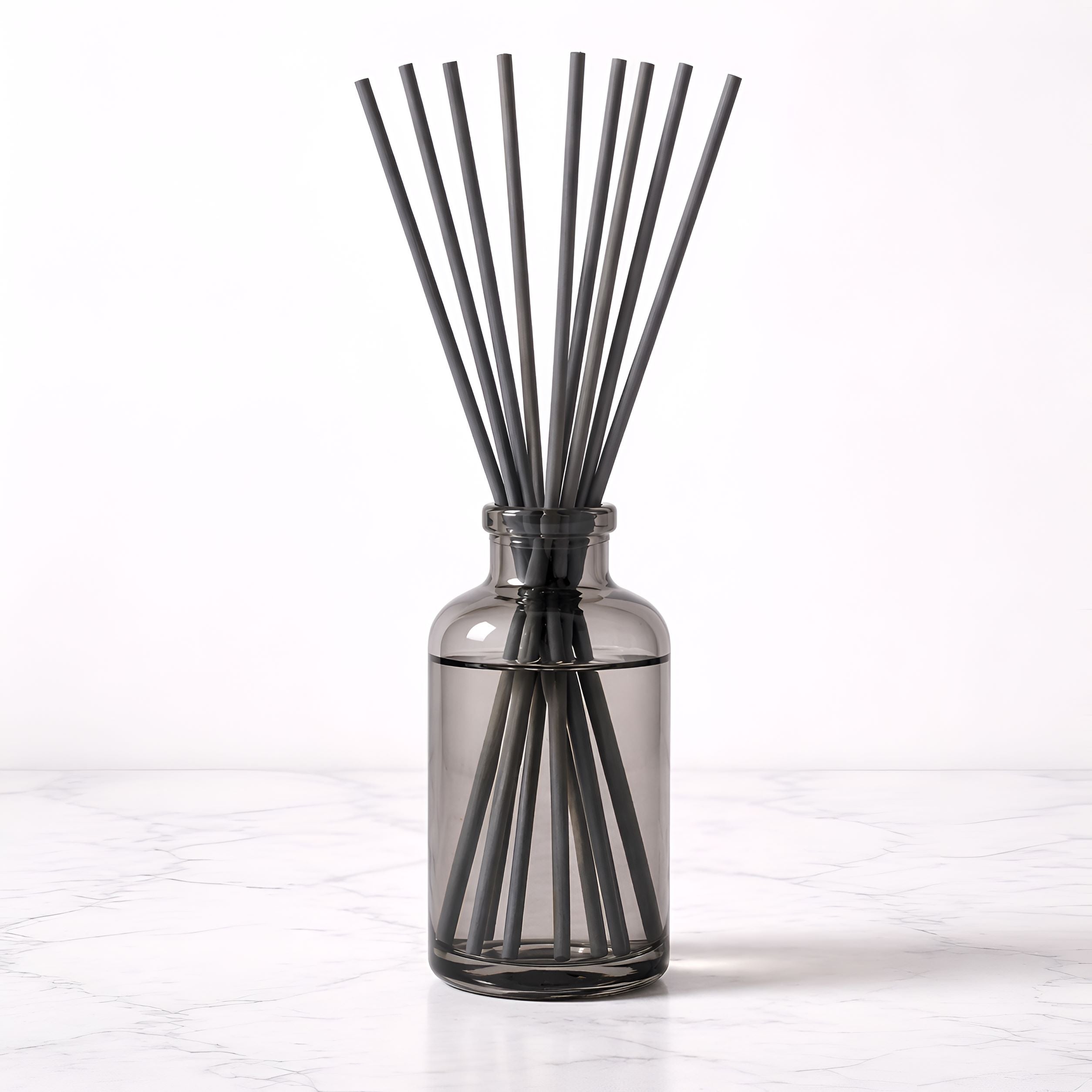 Smoky gray diffuser bottle with gray reed sticks on a white background