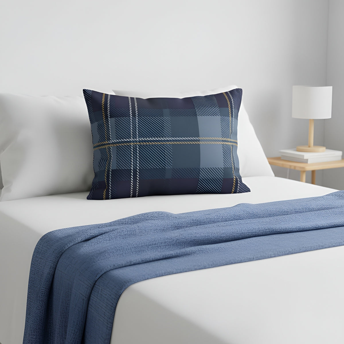 Blue plaid pillow sham on a white bed with a blue throw blanket