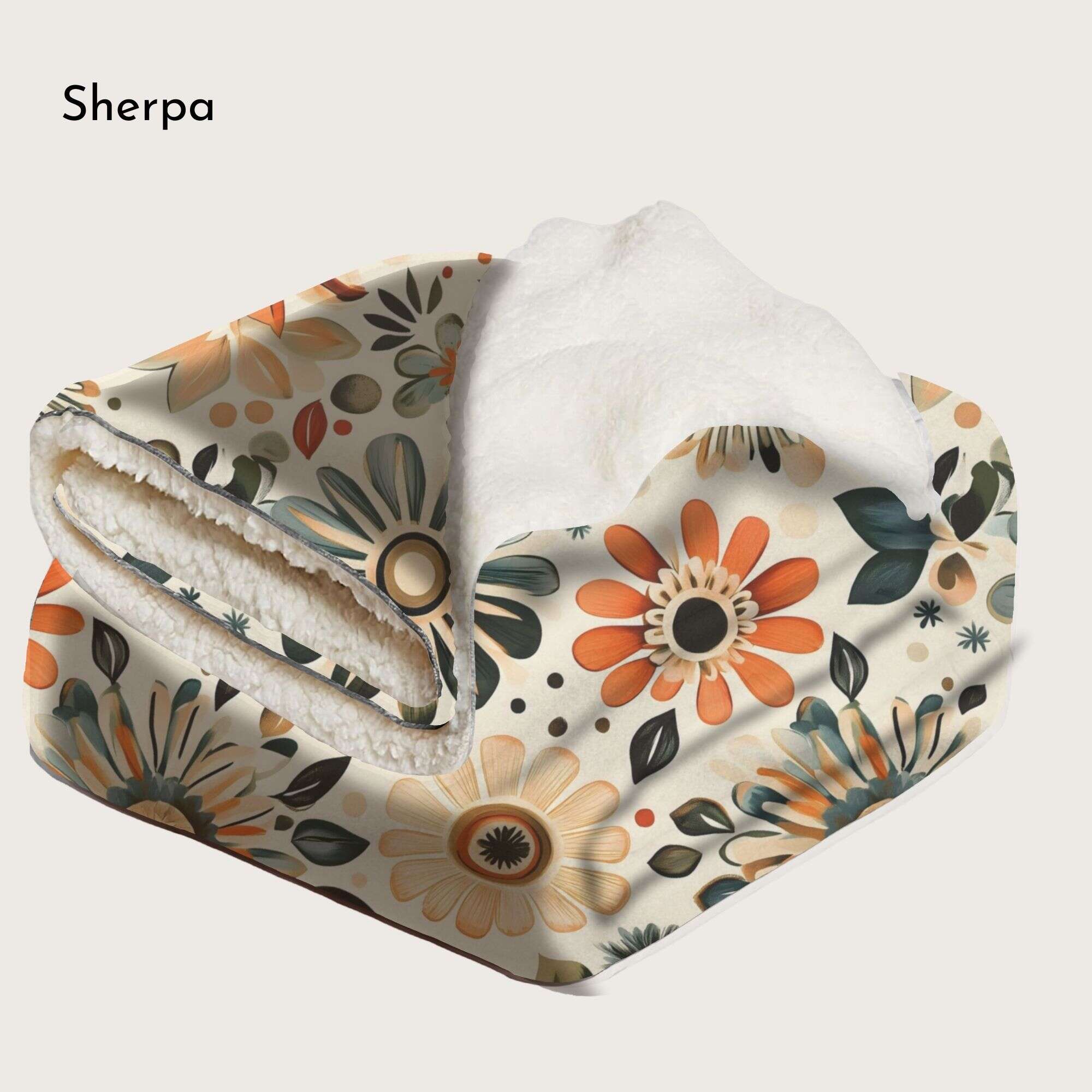 A floral throw blanket with shades of orange, green, and beige in sherpa fabric folded on a white background.