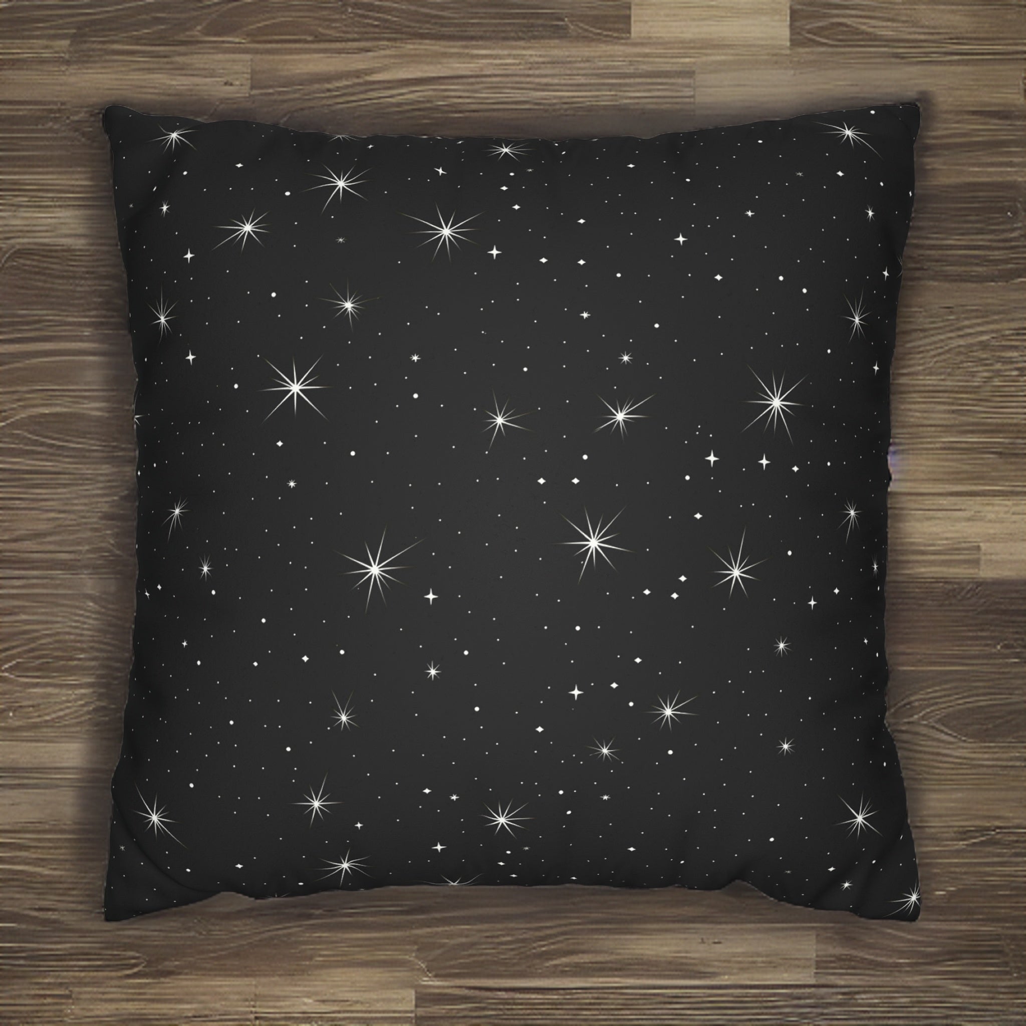 A faux suede pillow cover with a black background and a white starry night sky pattern.