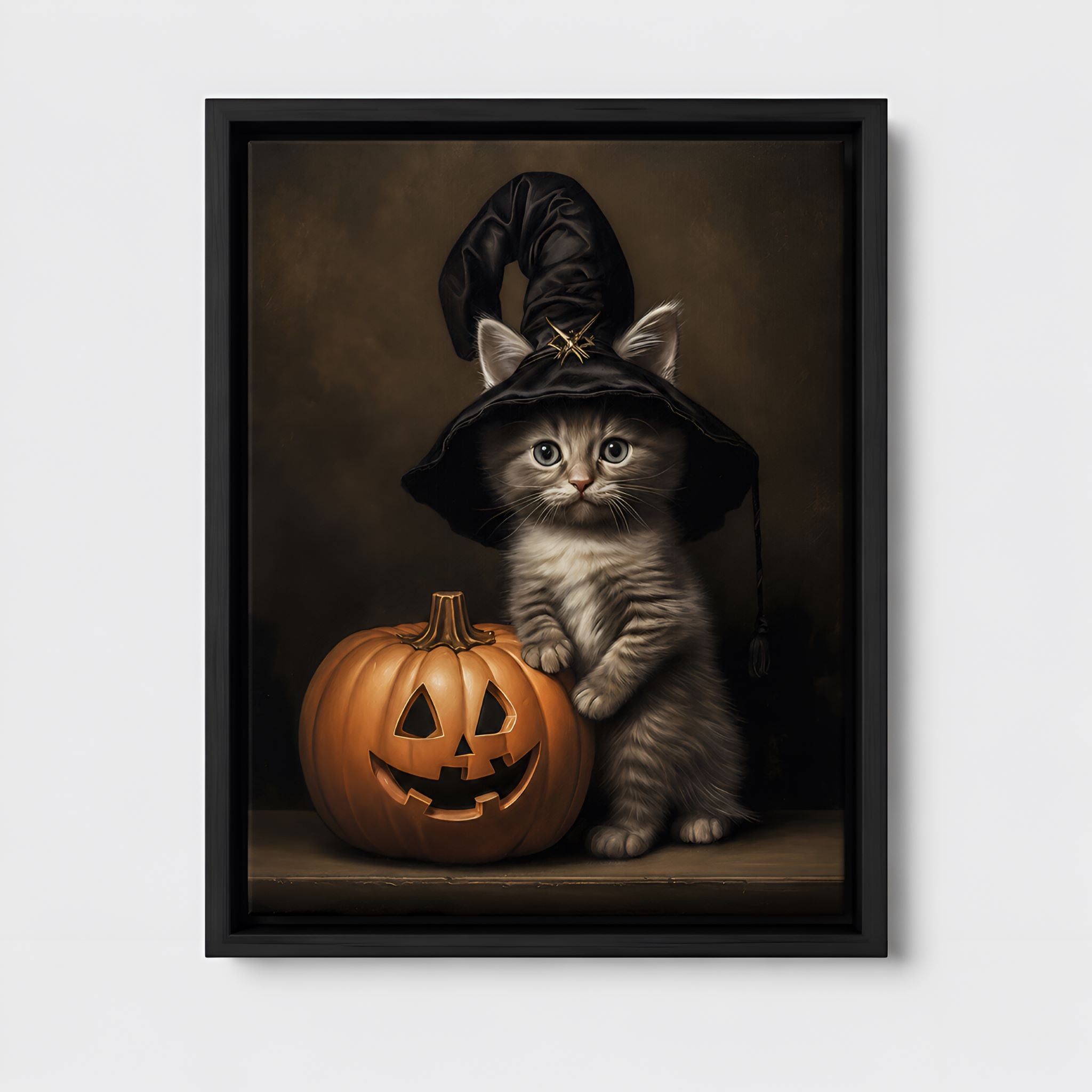 Framed artwork of a cat in a witch hat with a pumpkin on a white wall.