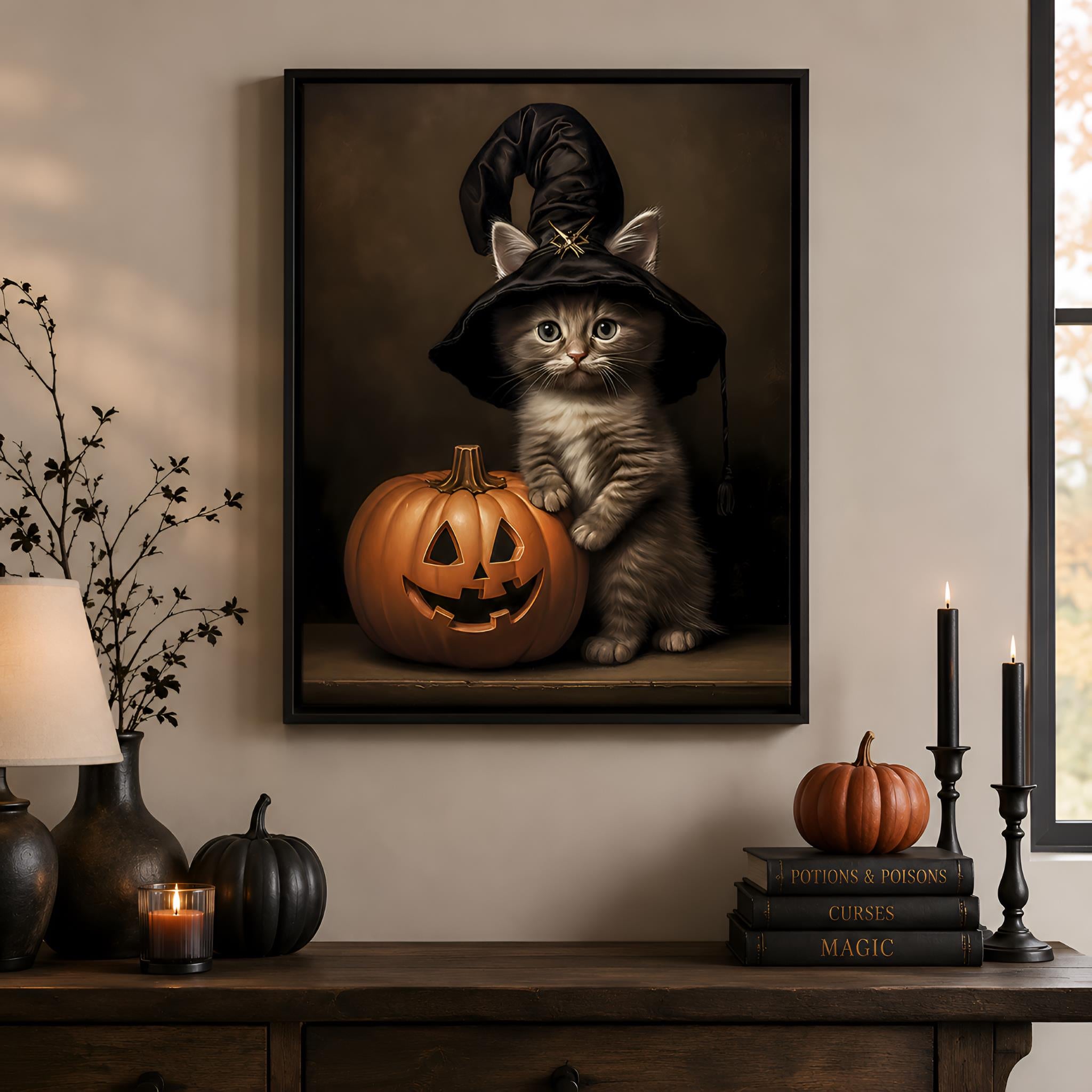 Framed Halloween-themed artwork of a cat in a witch hat with a pumpkin on a wall above a wooden table.