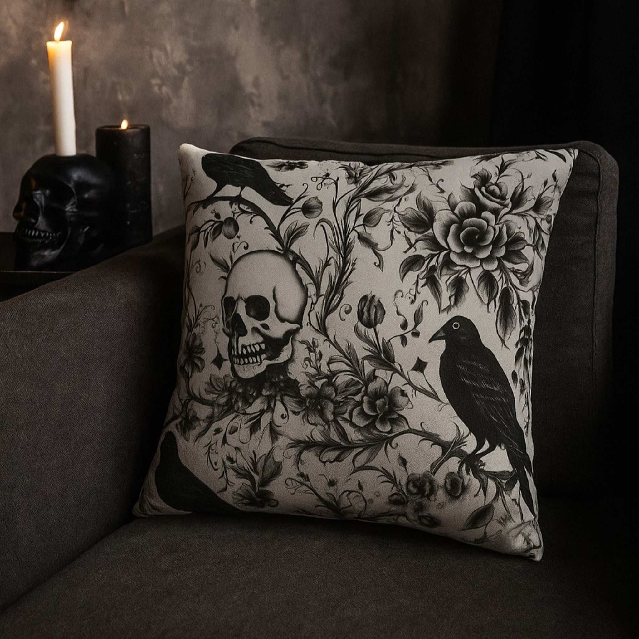 Decorative pillow with skull and floral design on a dark couch.