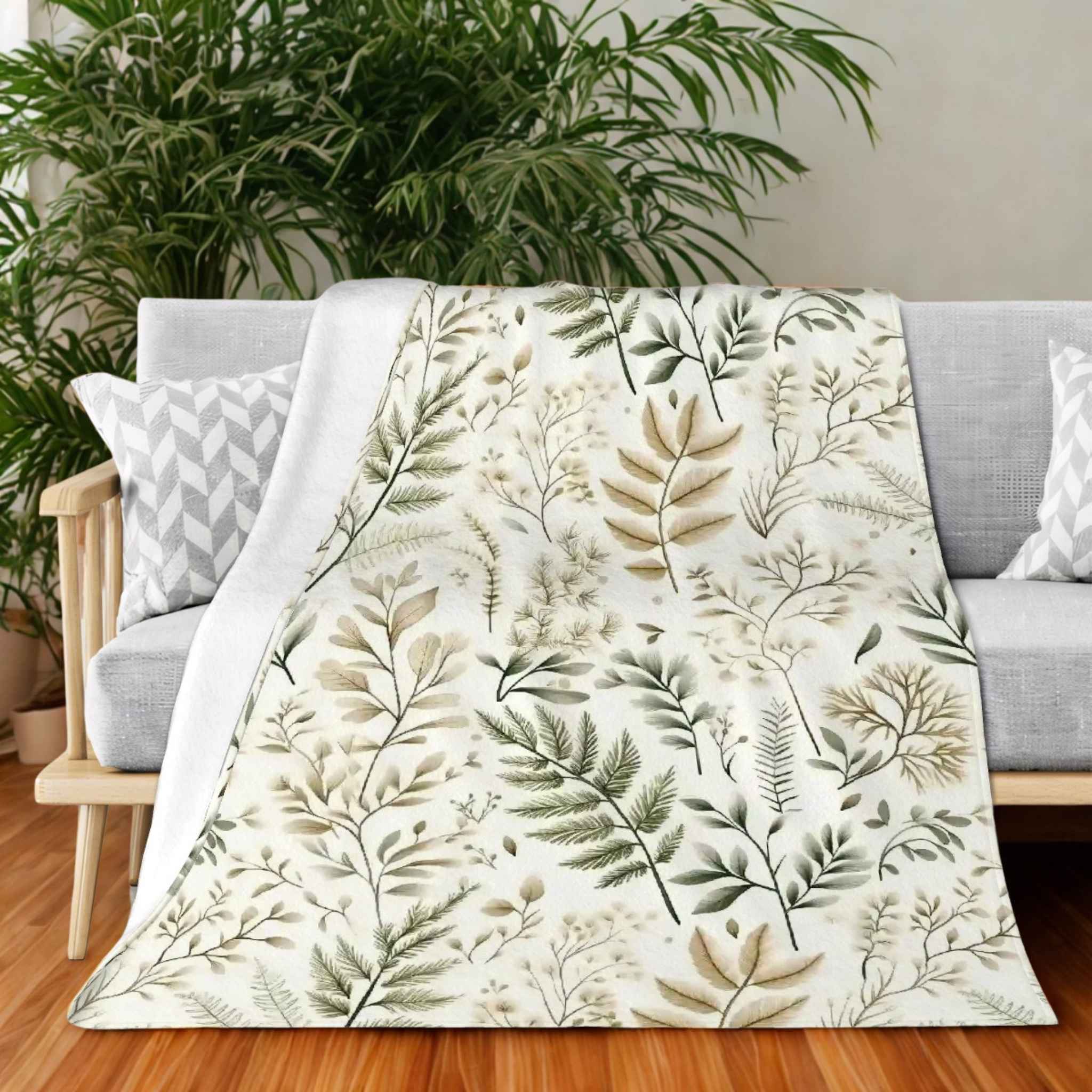 Floral-patterned blanket draped over a sofa with plants in the background