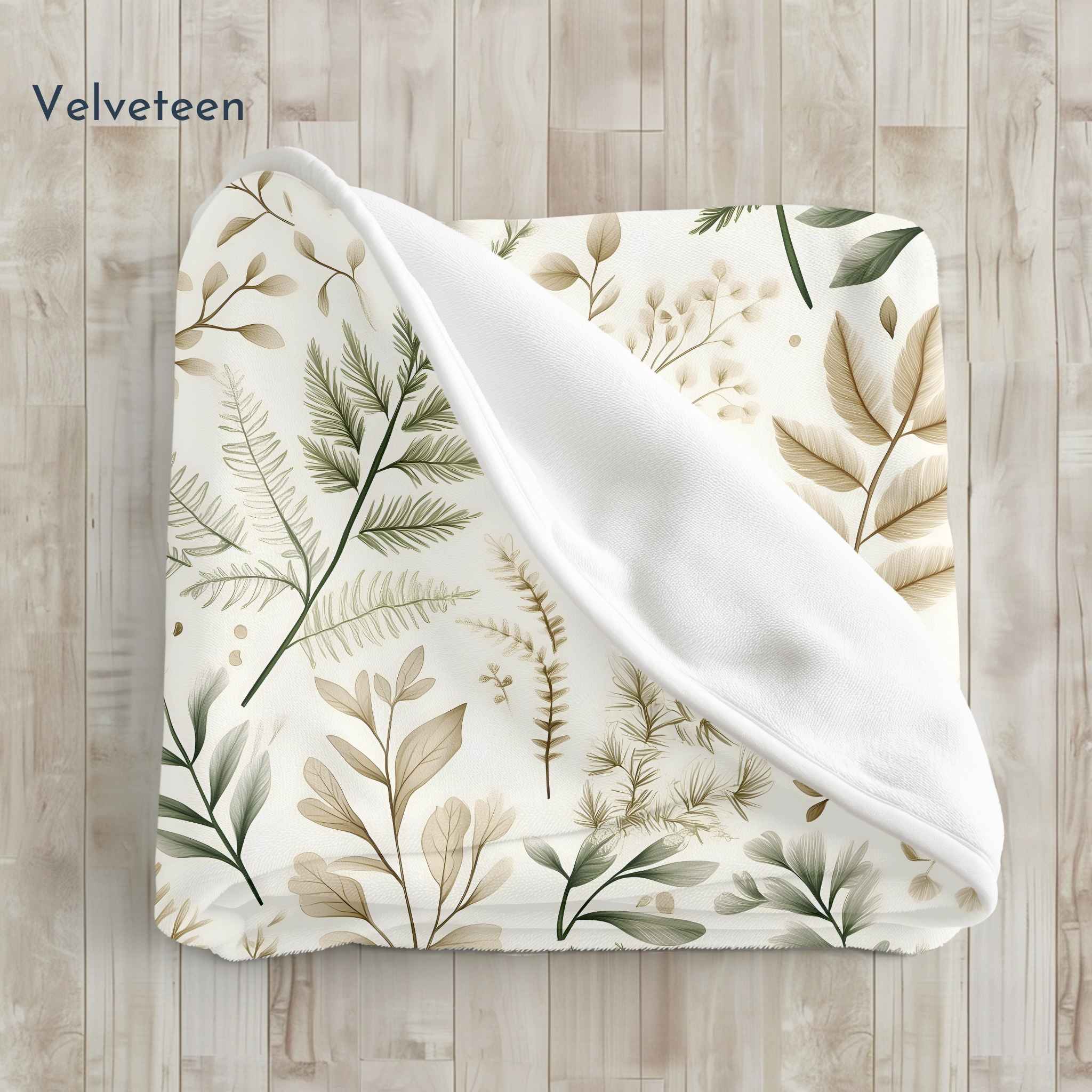 Velveteen blanket folded with leaf pattern on a wooden surface