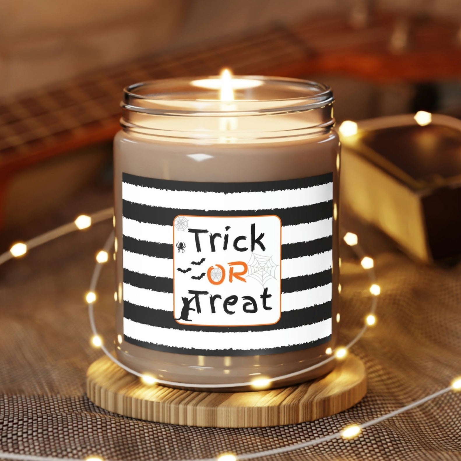 Trick or Treat Candle, Comfort Spice, Eco-Friendly Soy Wax 9oz wrapped in lights on table coaster
