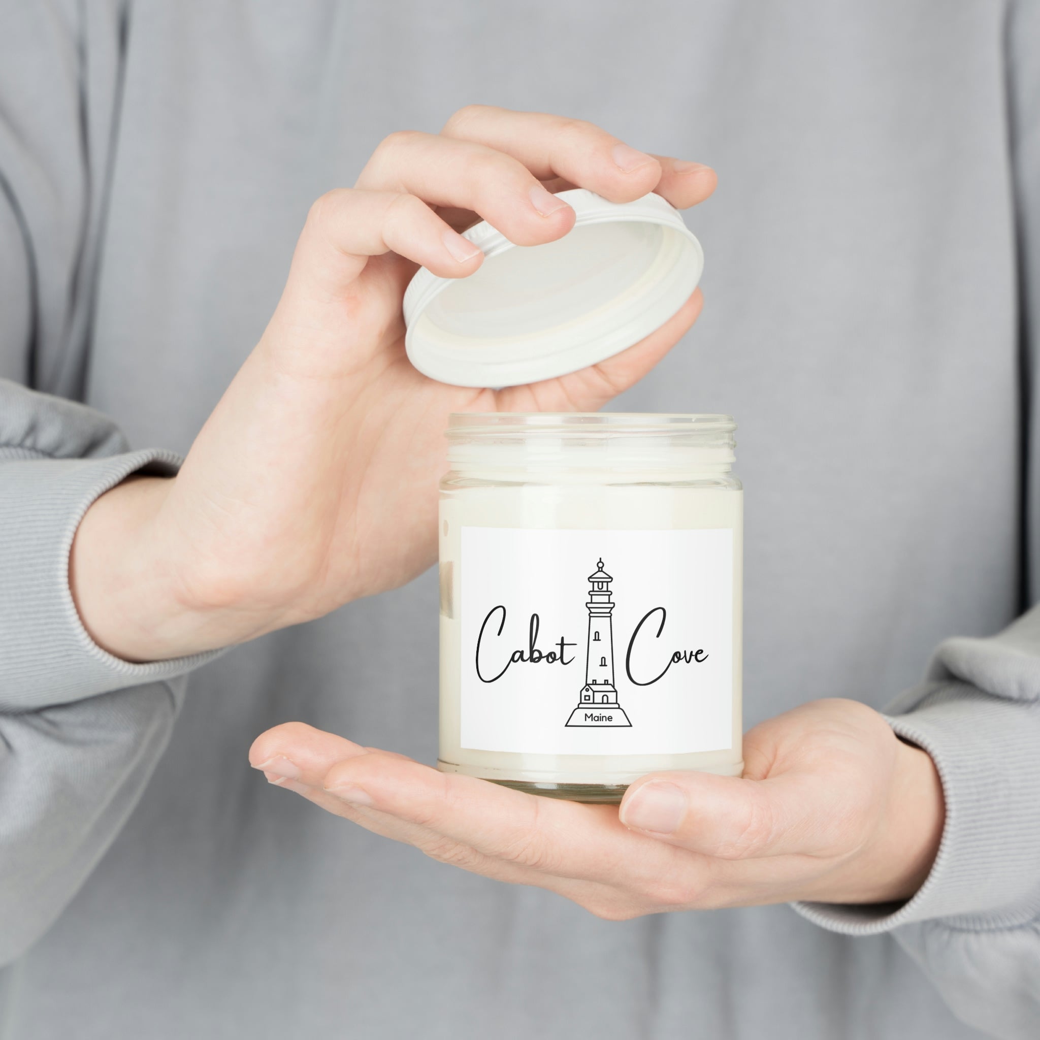 Women holding a close up shot of Cabot Cove Soy Candle