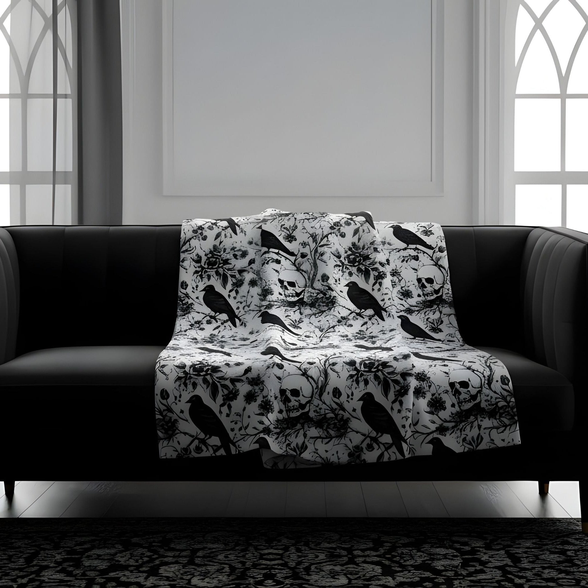 Gothic velveteen throw blanket with black and white skull, raven, and floral pattern  on black sofa.