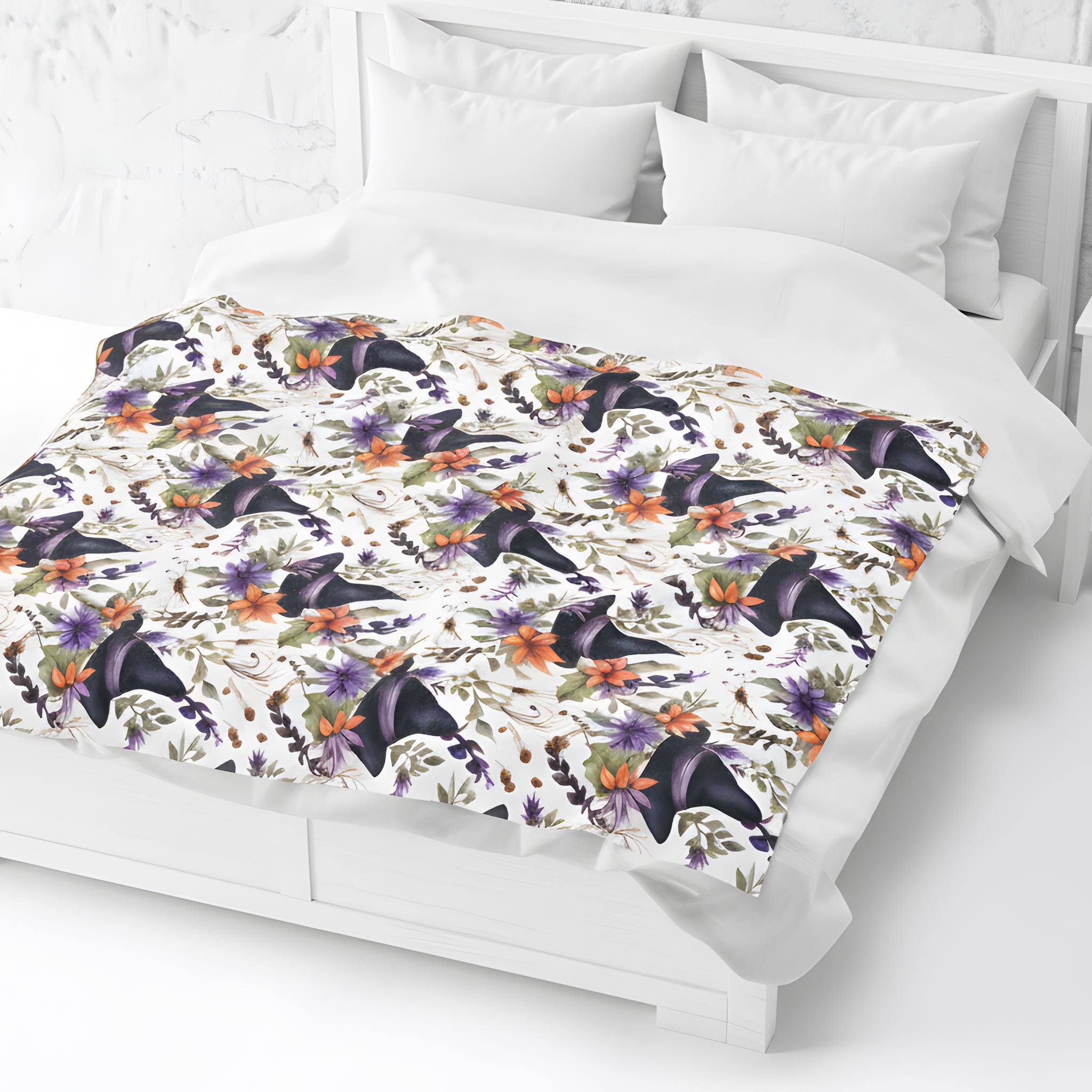 Gothic floral throw blanket spread across a bed with witch hat pattern and white bedding.