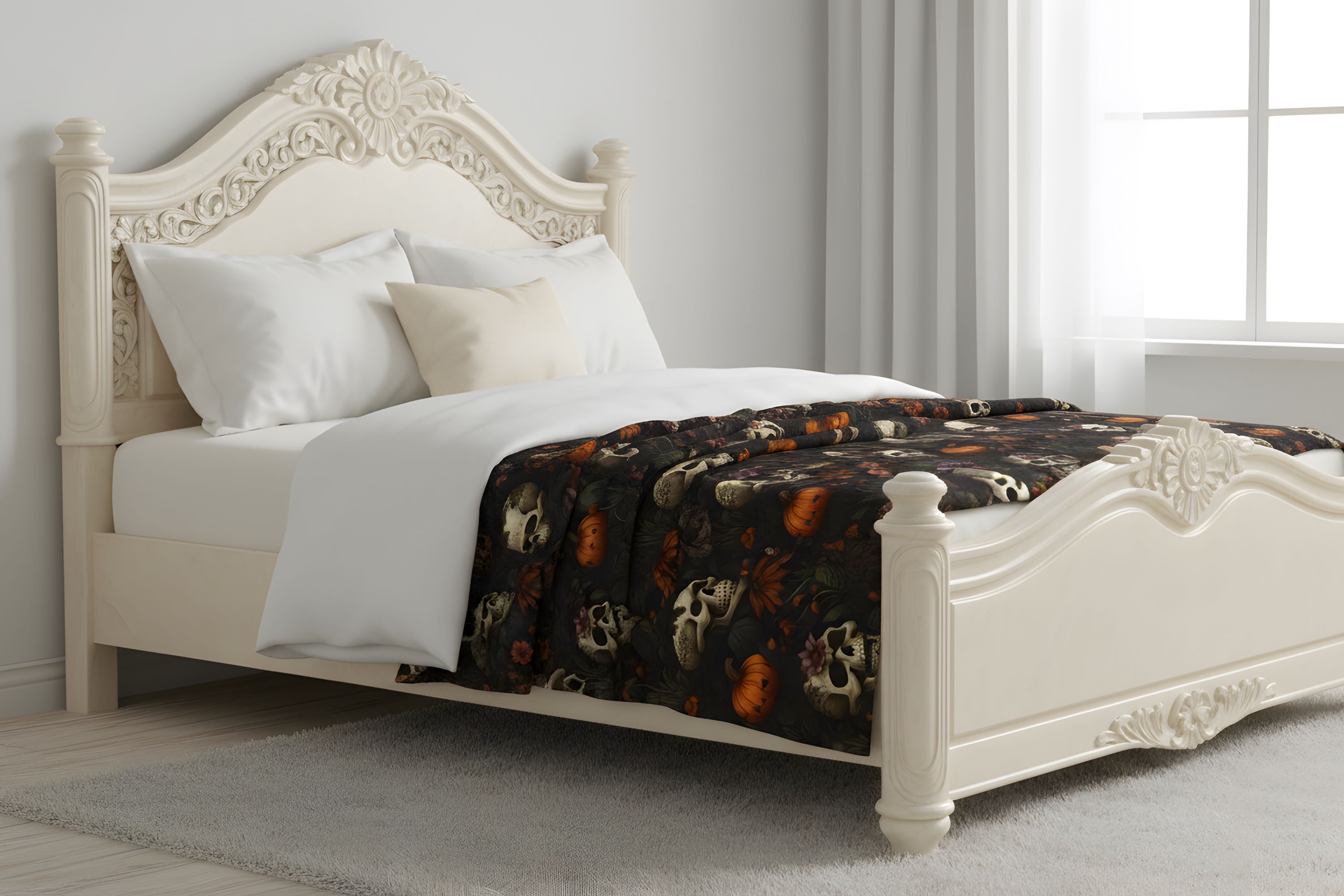 Dark floral Halloween throw blanket spread across a cream bed in a light neutral room.