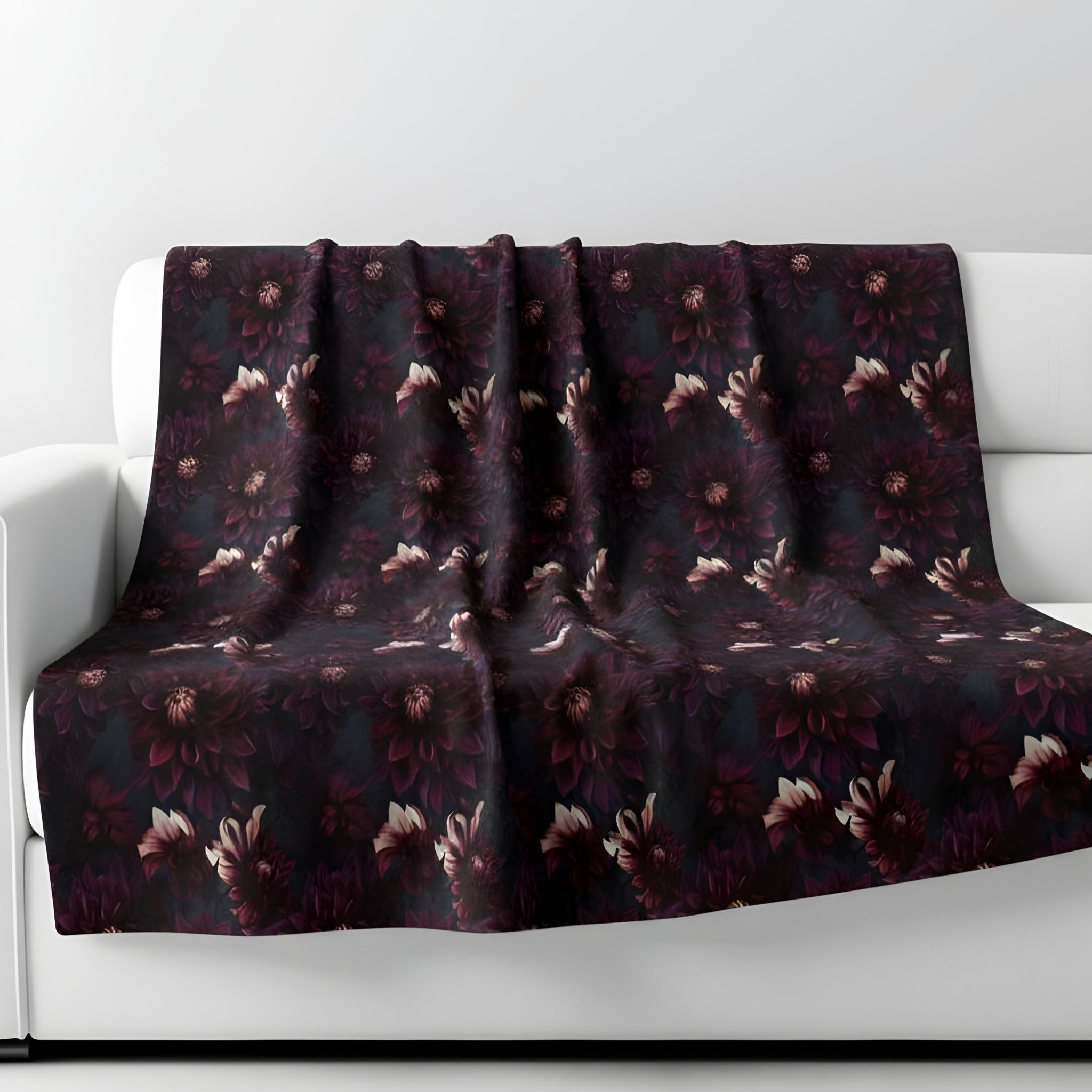 Purple floral blanket draped over a white sofa against a light gray background