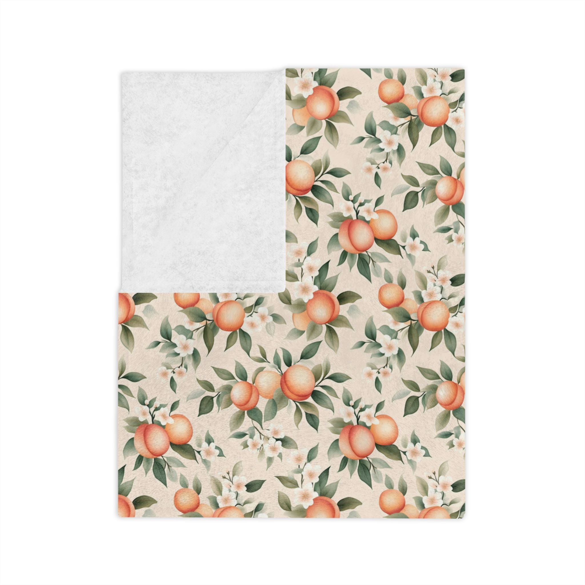 A folded velveteen throw blanket with a peach fruit pattern.