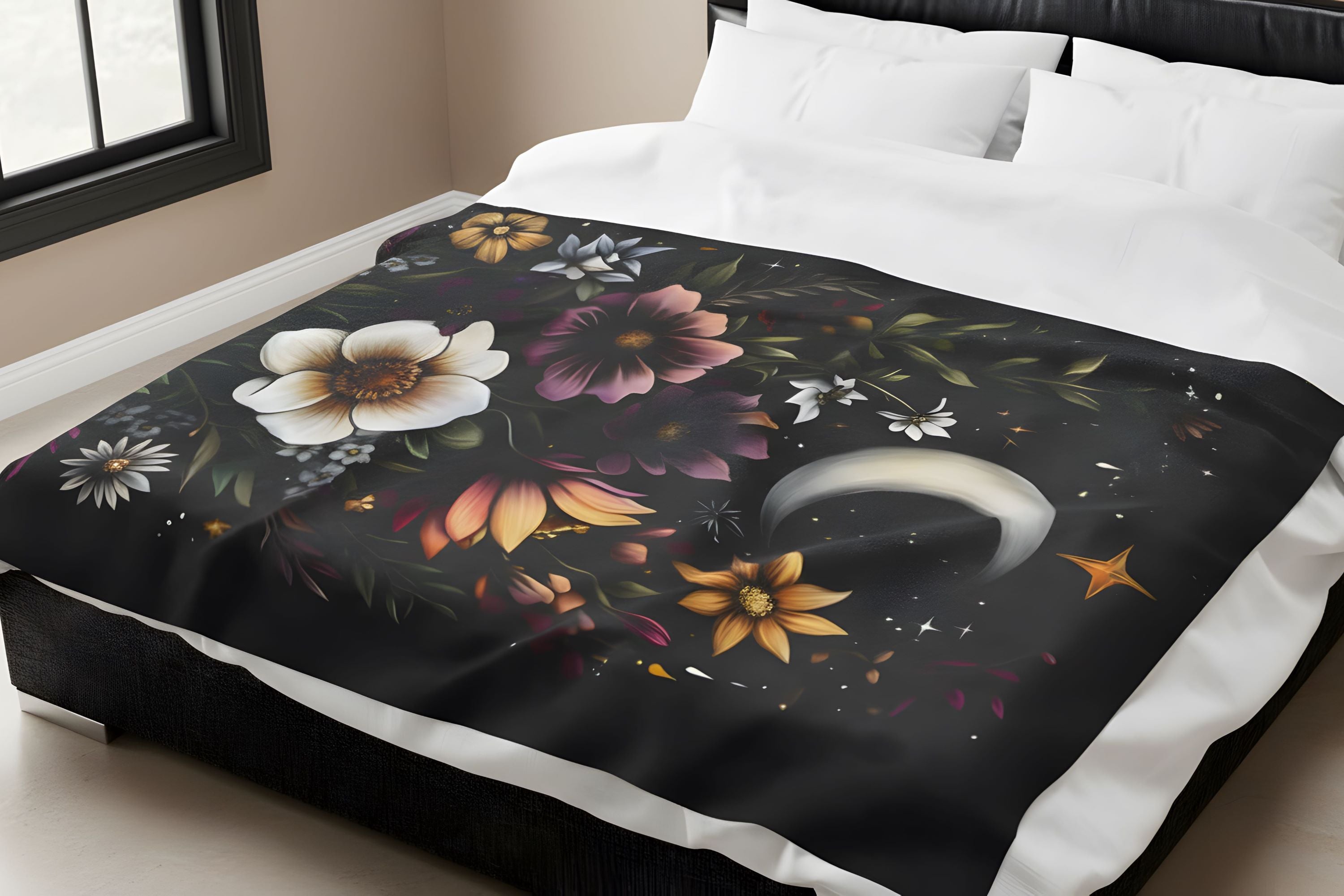 Floral and moon lightweight velveteen throw blanket on a bed with white bedding.