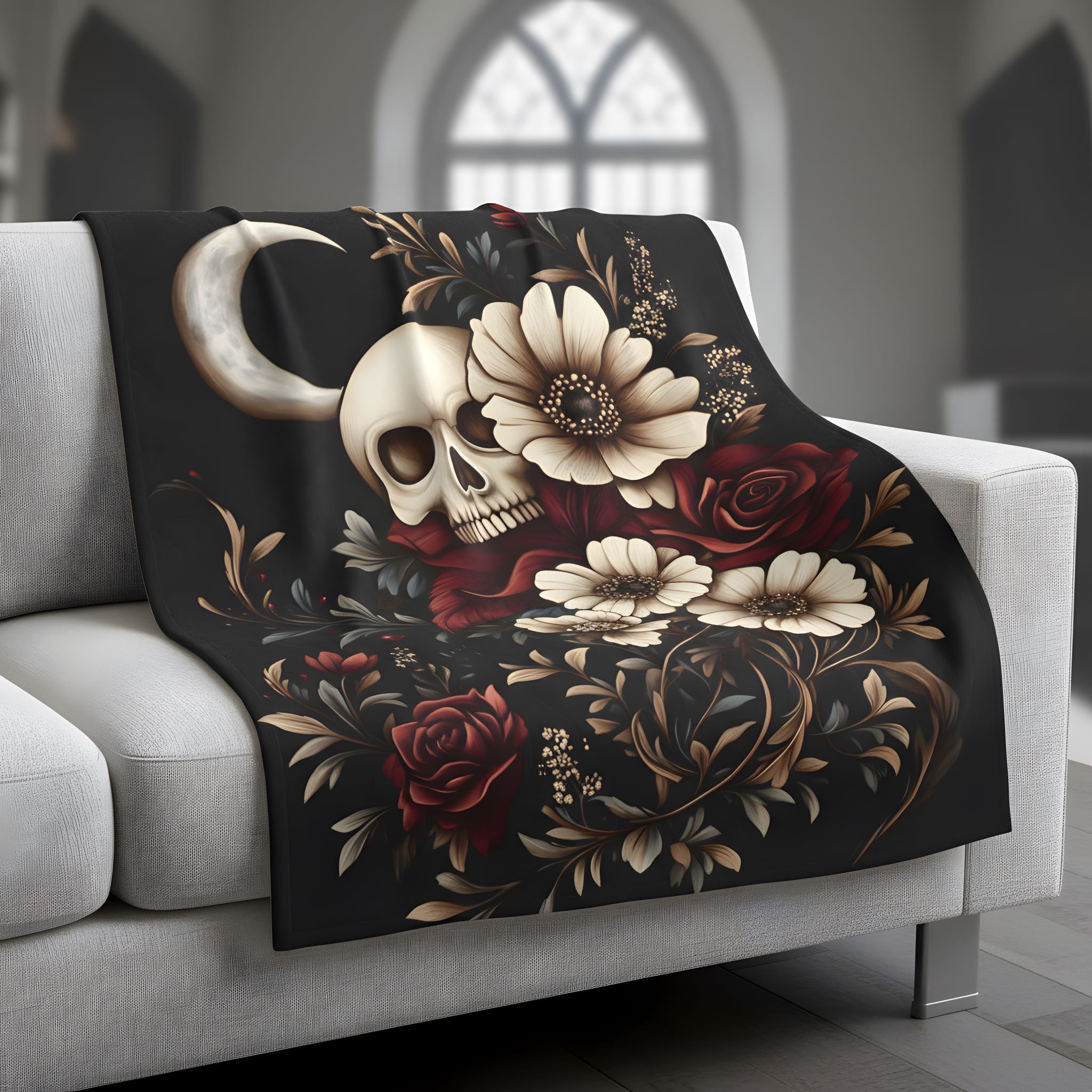 Moody botanical lightweight, velveteen throw blanket on sofa with skull, moon detail, cream flowers, and red roses.