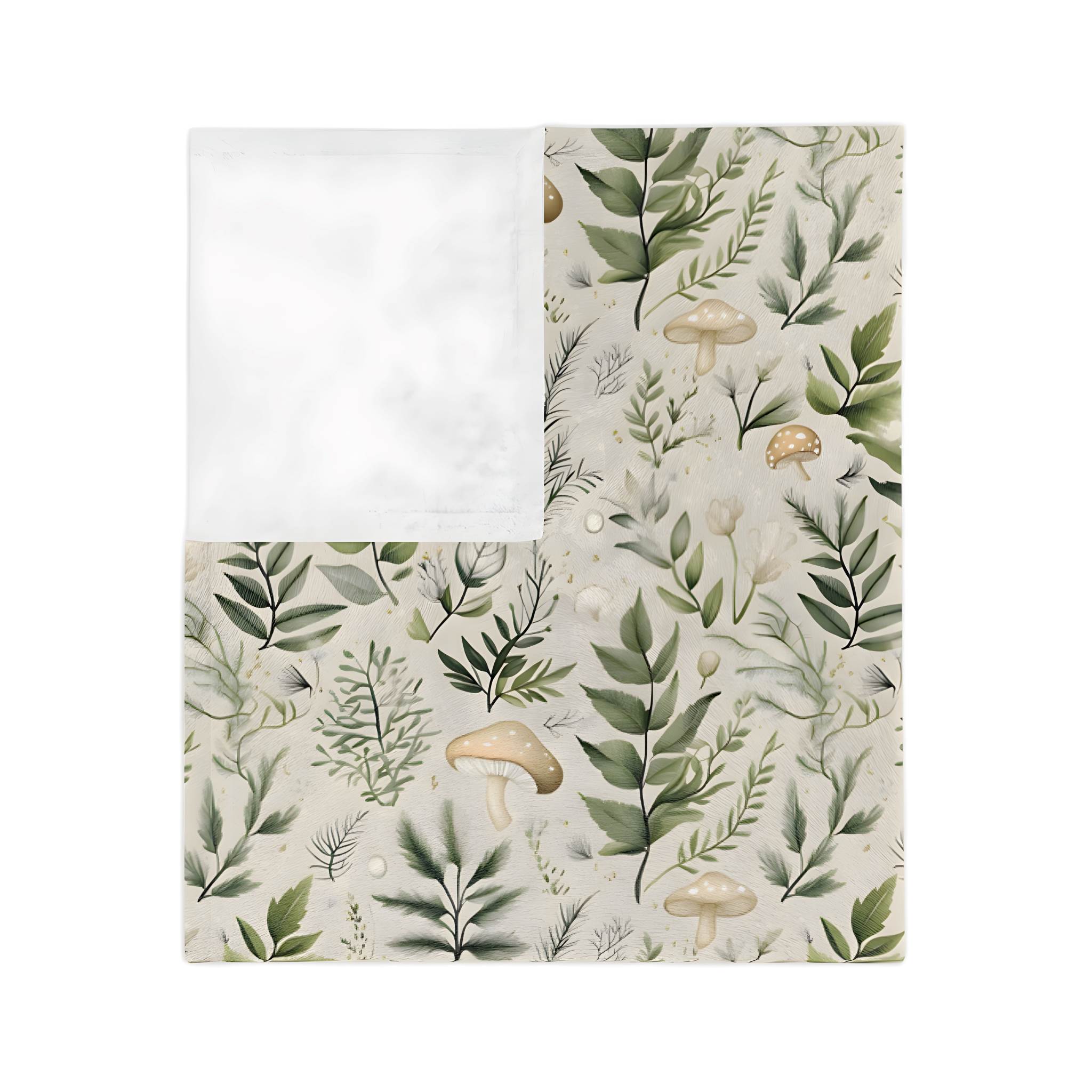 Folded botanical throw blanket with green leaves and mushroom accents on an blanket with a white backside.