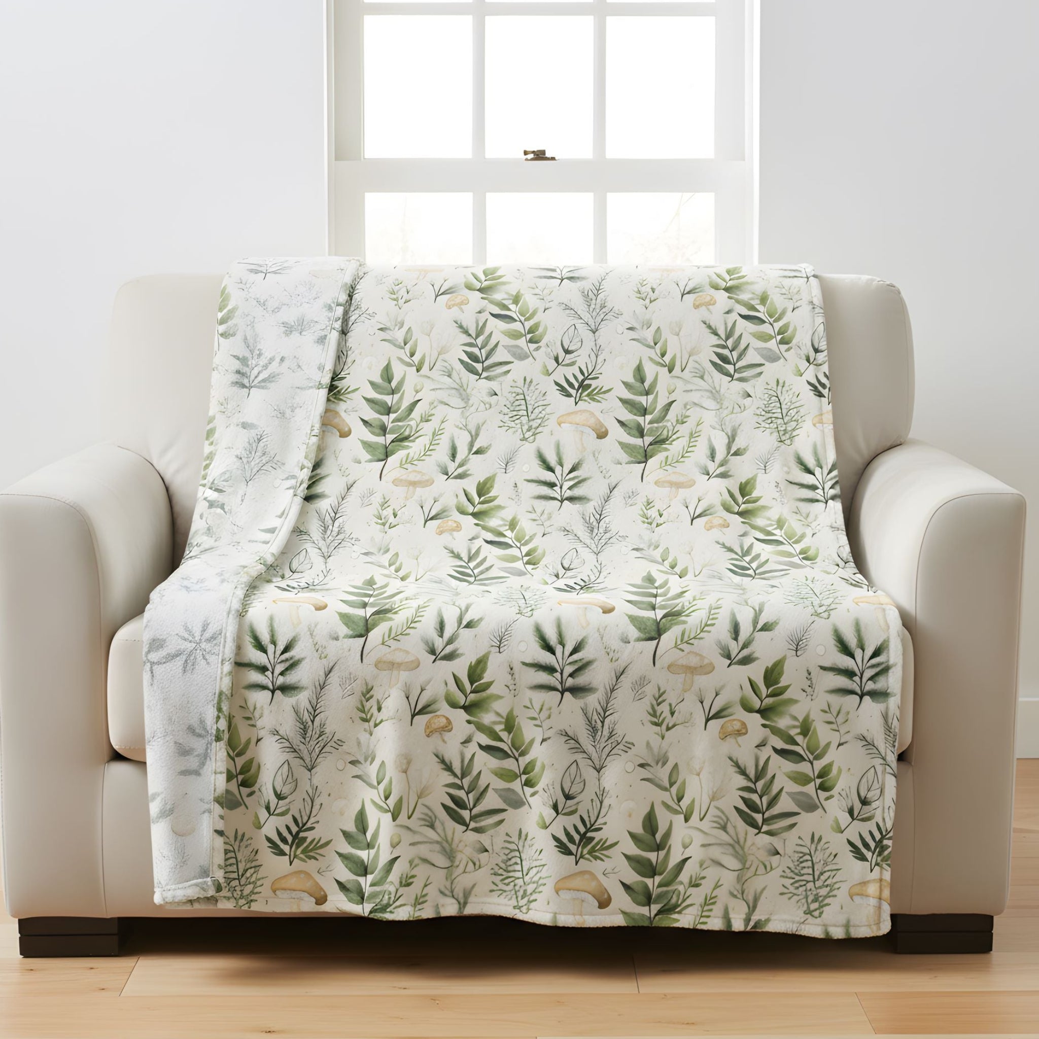 Botanical velveteen throw blanket draped over a white armchair in a light cottage-inspired room.