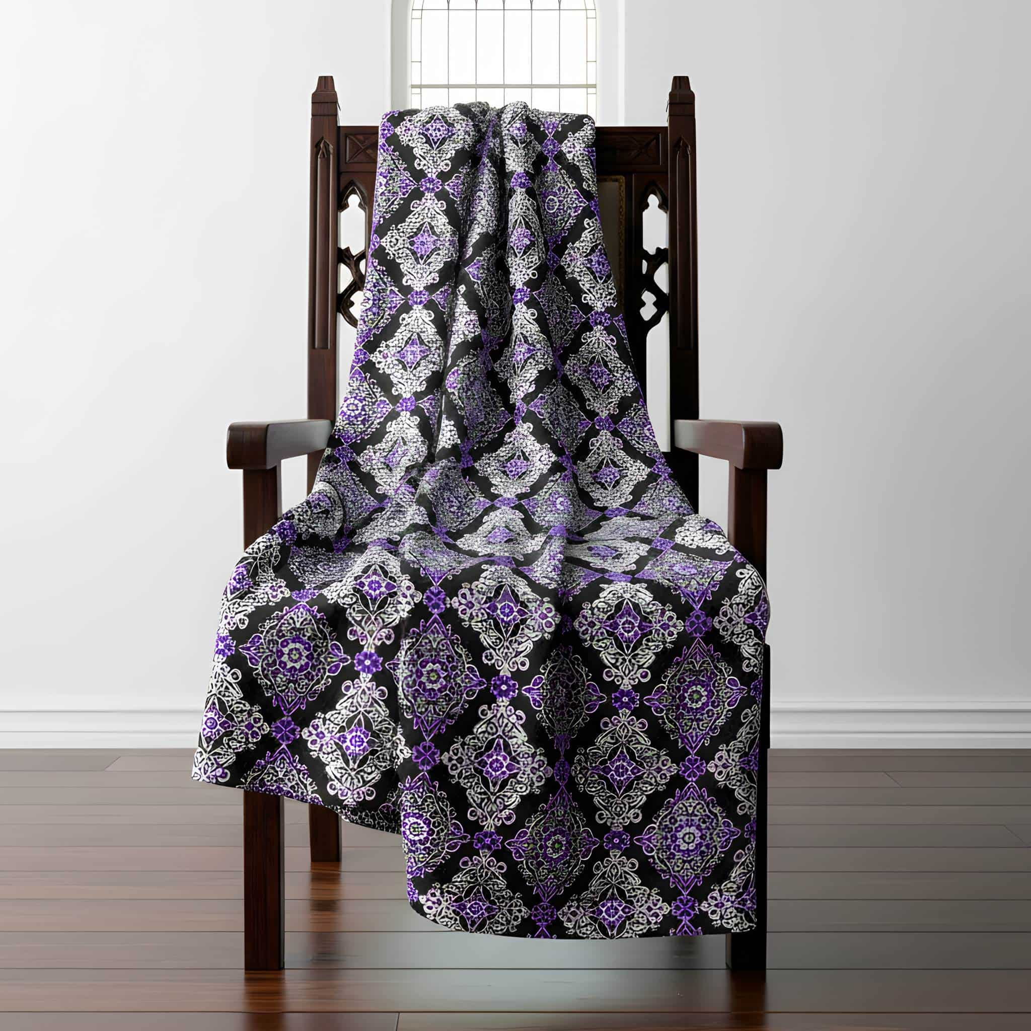 Damask patterned throw blanket draped over a orante gothic wooden chair.