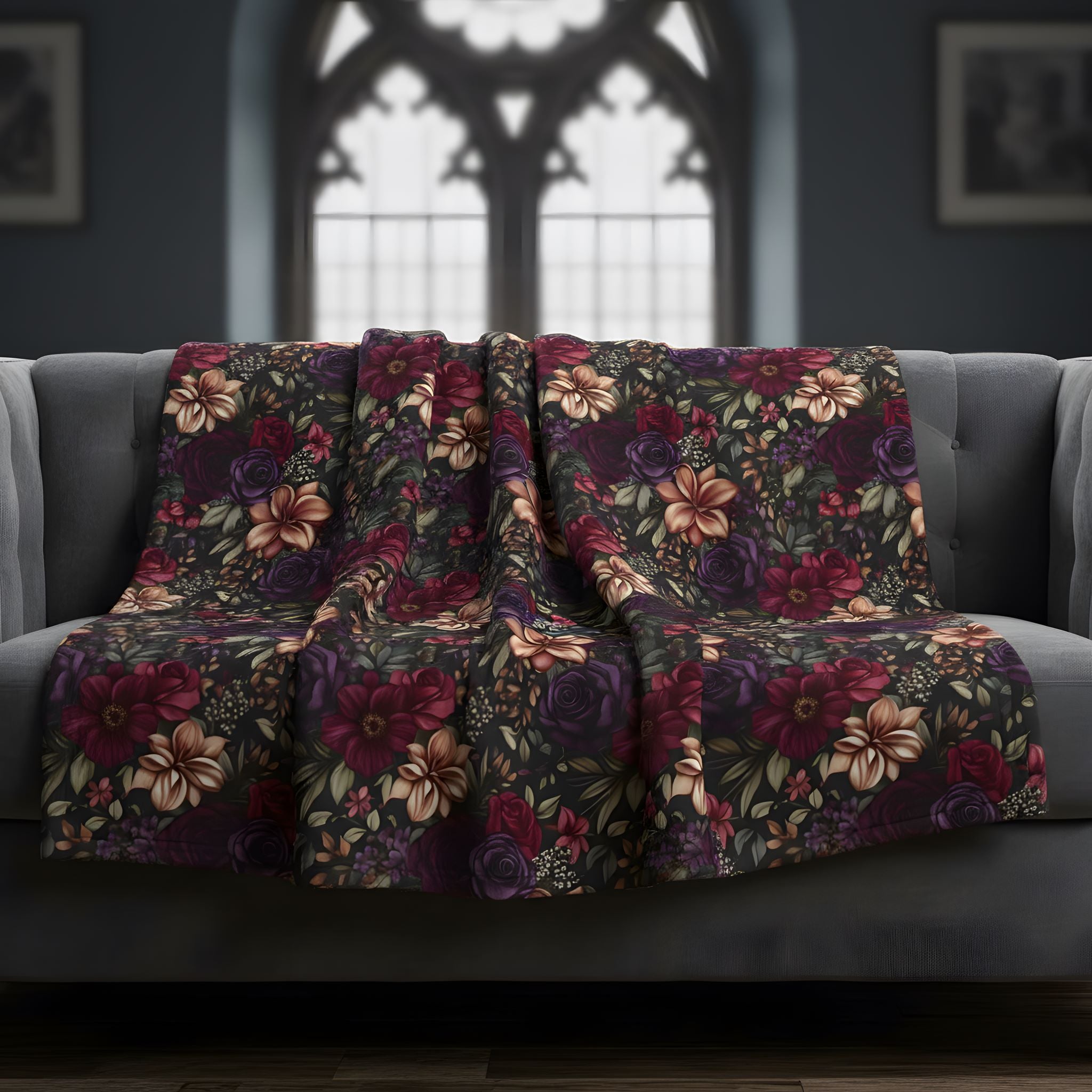 Midnight Bloom dark floral blanket styled on a sofa beneath an arched Gothic window.