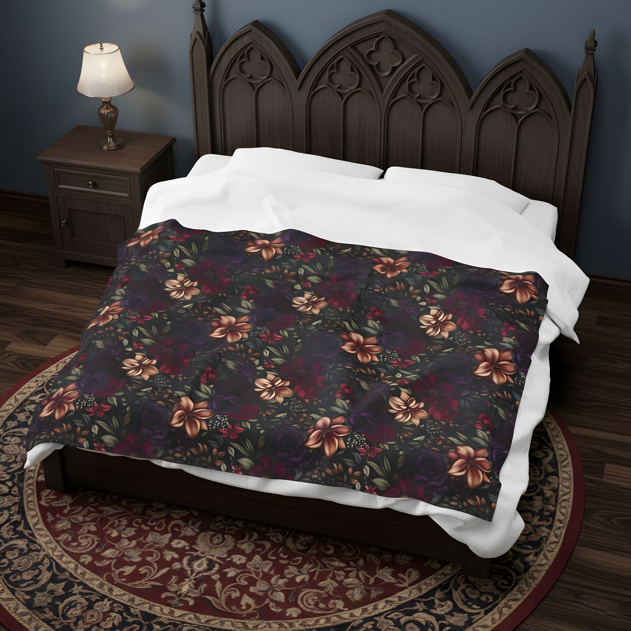 Dark floral throw blanket spread across a bed with Gothic styling and carved wood headboard.