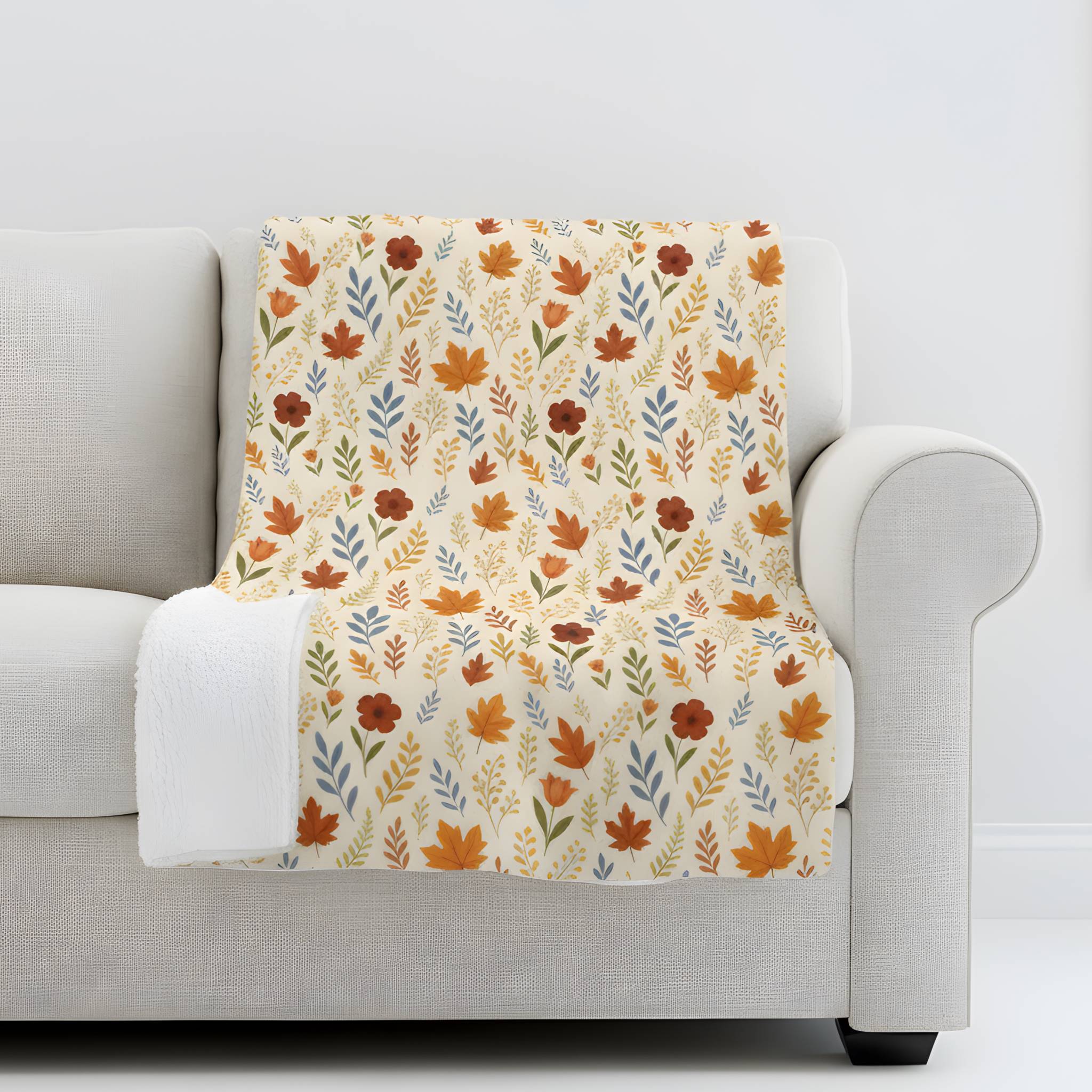 Autumn leaf throw blanket draped over a gray sofa.