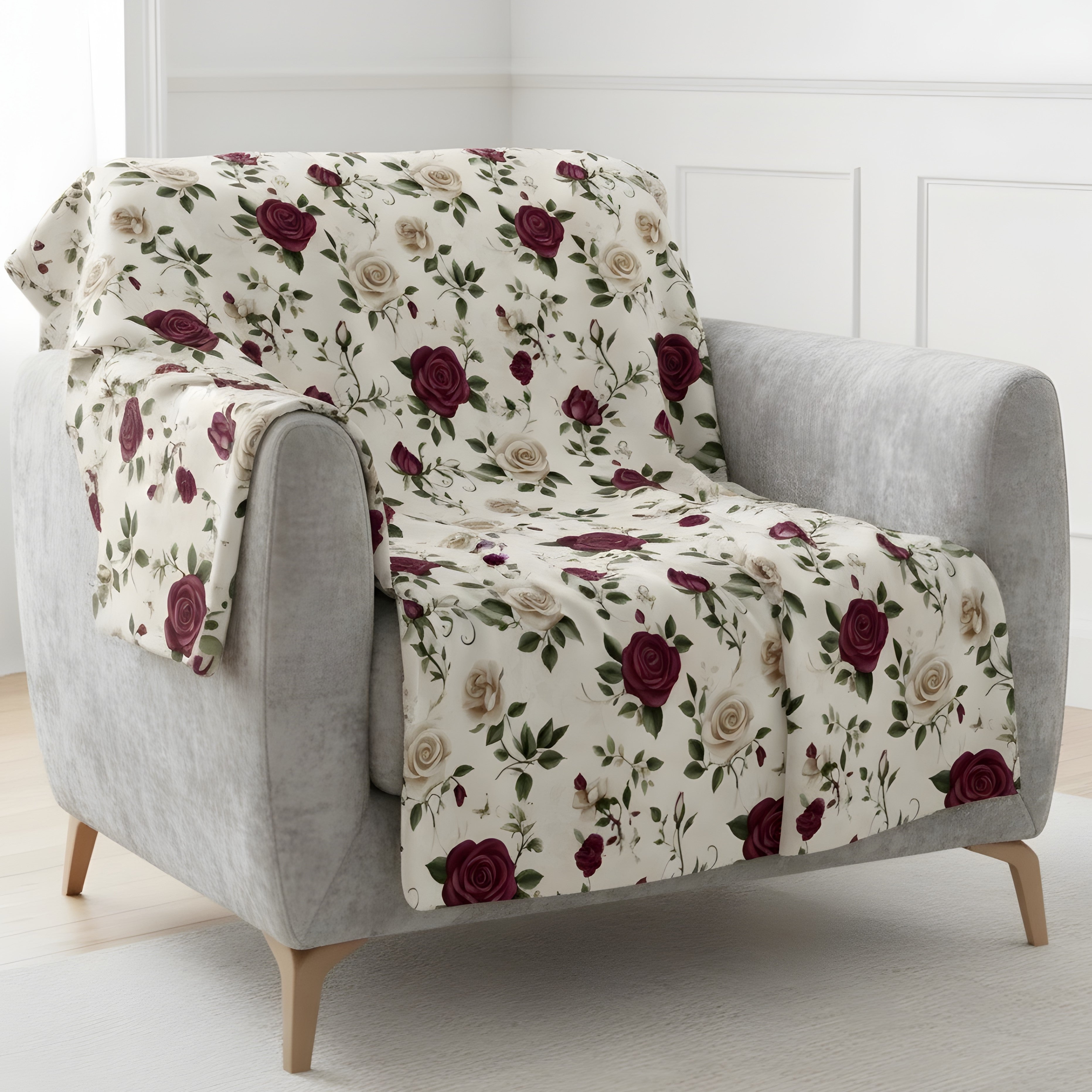 Vintage rose throw blanket on gray chair in velveteen or sherpa with burgundy and cream floral design.