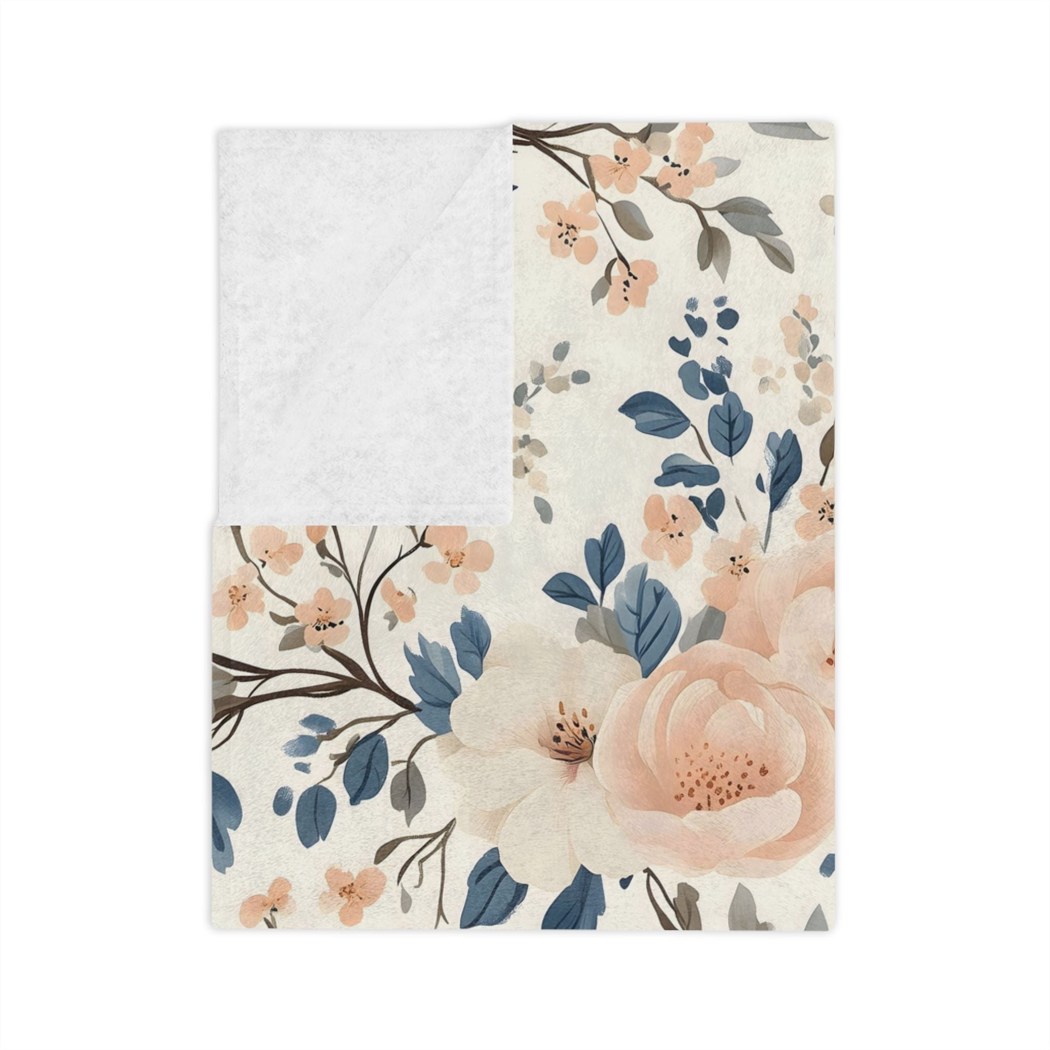 Folded velveteen blue bird throw blanket with peach flowers and soft botanical branches with white backing.