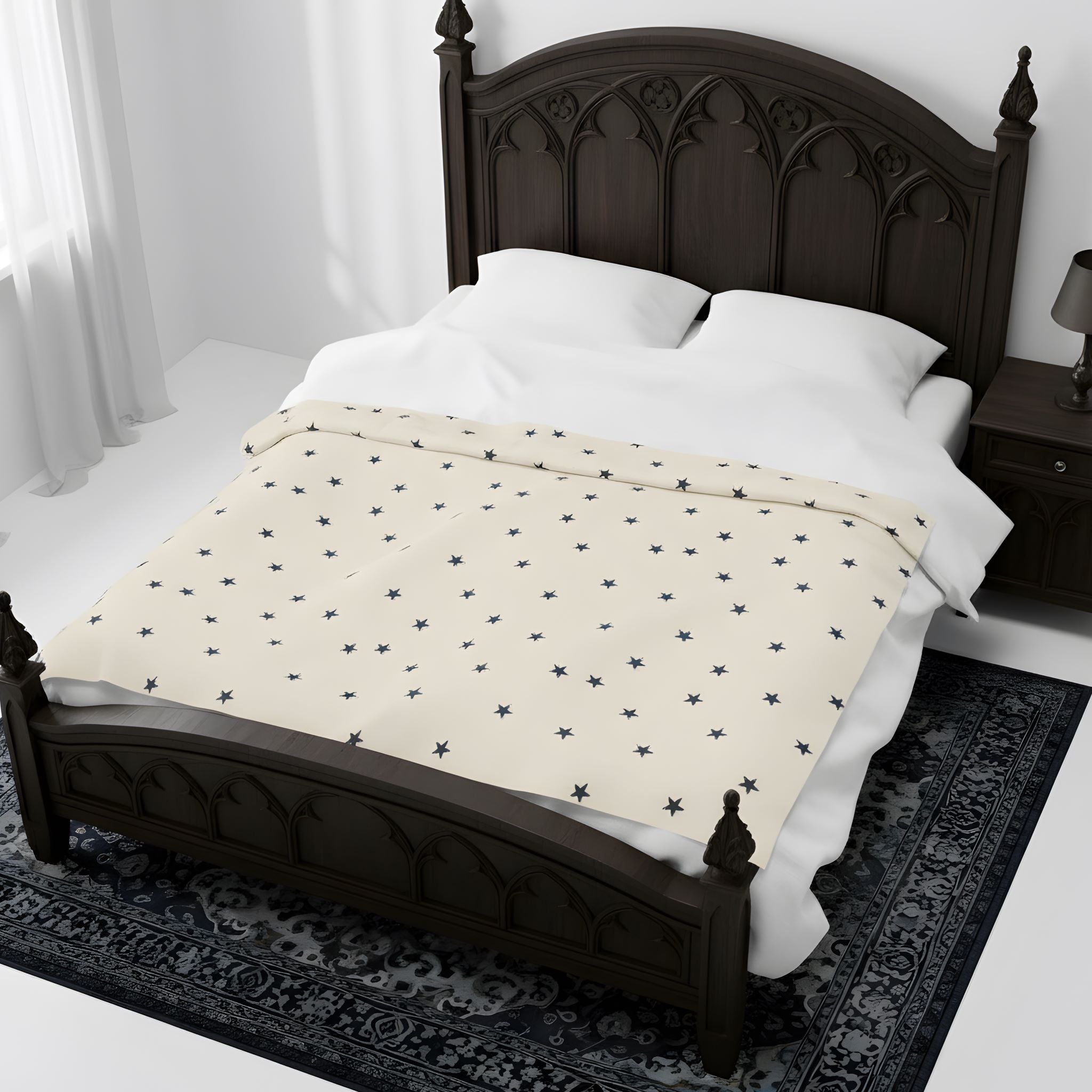 Celestial blanket spread across a bed with white bedding and dark wood headboard.