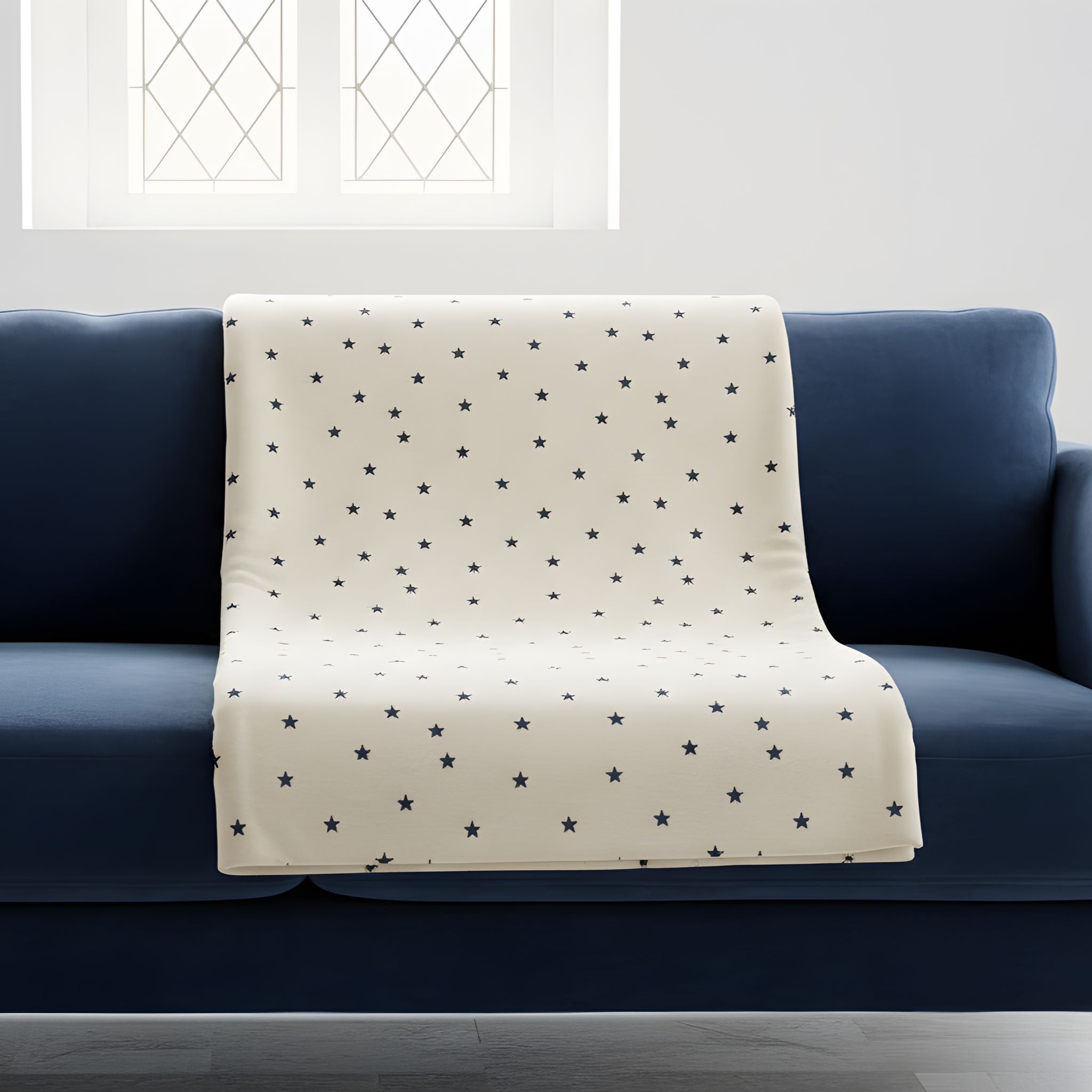 Soft Starfield celestial throw blanket draped over a blue sofa in a bright room.